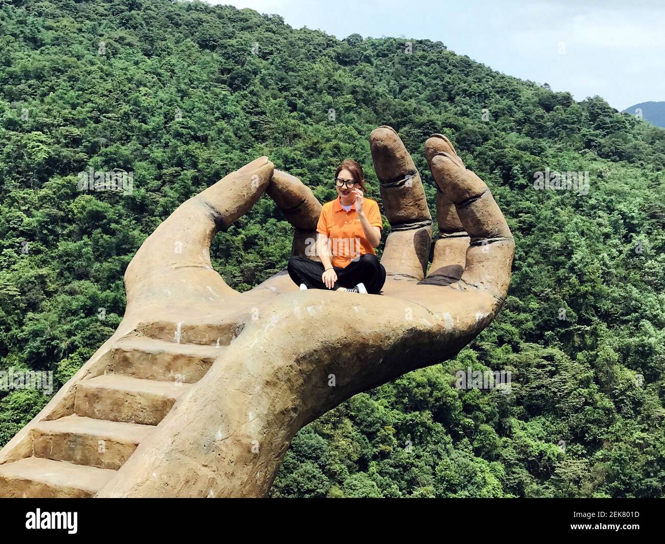Les touristes prennent des photos sur le célèbre site Internet de Gulong  Canyon, qui délonge à gauche du grand pont de passerelle en verre,  ressemblant à une main géante de Bouddha, ville