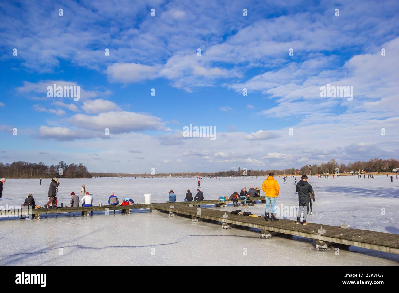 Personnes debout sur la jetée du lac gelé à Paterswolde, pays-Bas Banque D'Images