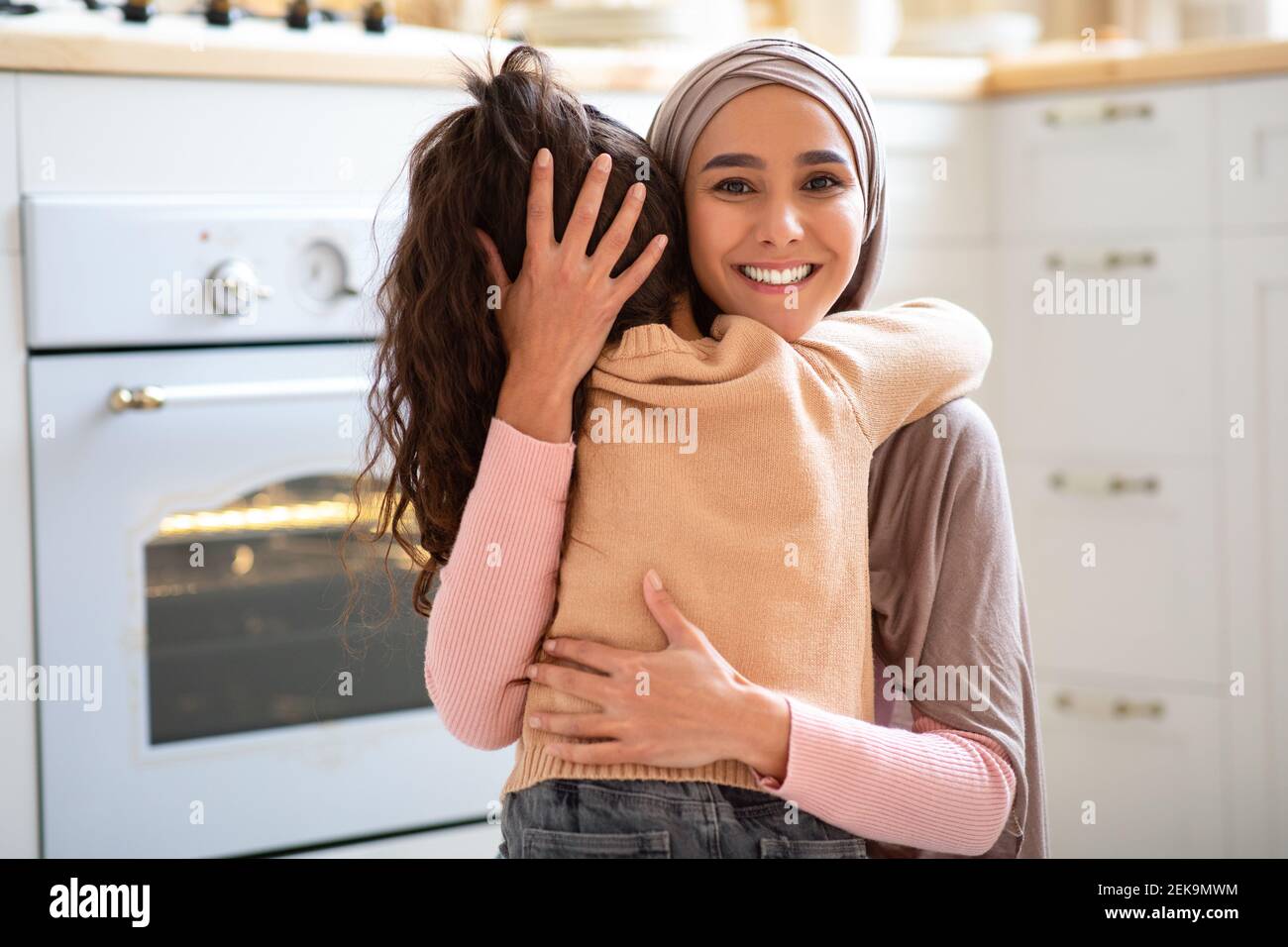 Mère fille Amour. Belle dame musulmane dans hijab embrassant son petit enfant Banque D'Images