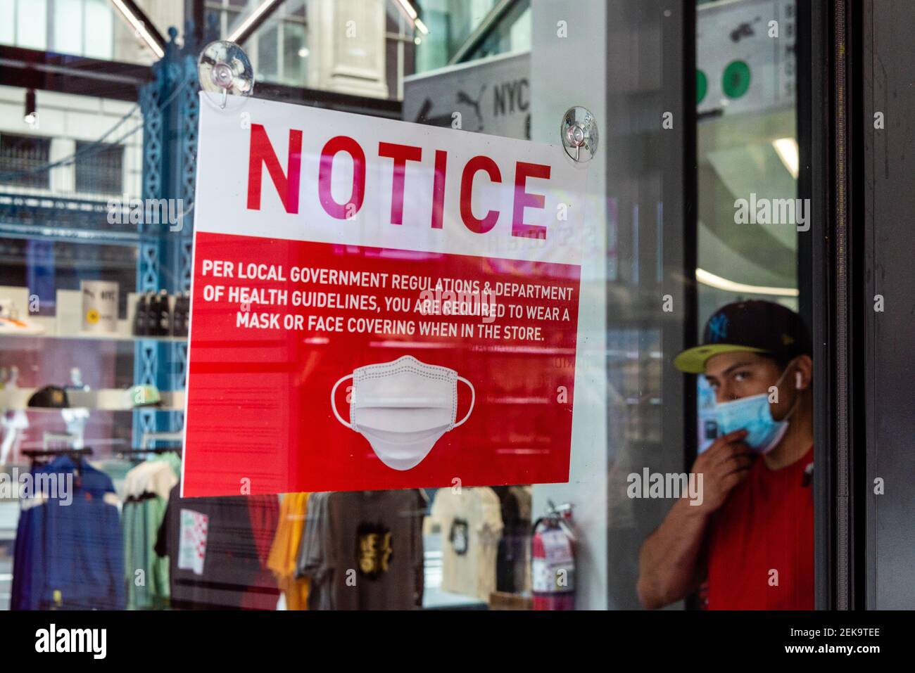 Une enseigne à l'intérieur du magasin PUMA rappelle à ses clients que le port d'un masque est obligatoire tandis qu'un homme portant un masque de marche quitte le magasin le 17 juillet 2020, à New York. (Photo de Gabriele Holtermann/Sipa USA) Banque D'Images