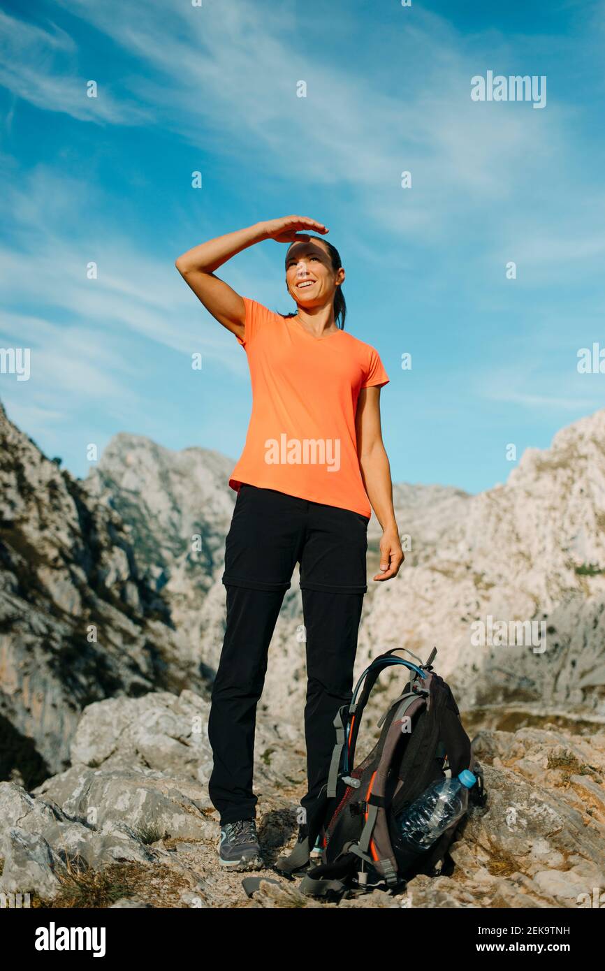 Femme qui se protège des yeux tout en regardant la vue sur la montagne à Cares Trail dans le parc national de Picos de Europe, Asturies, Espagne Banque D'Images