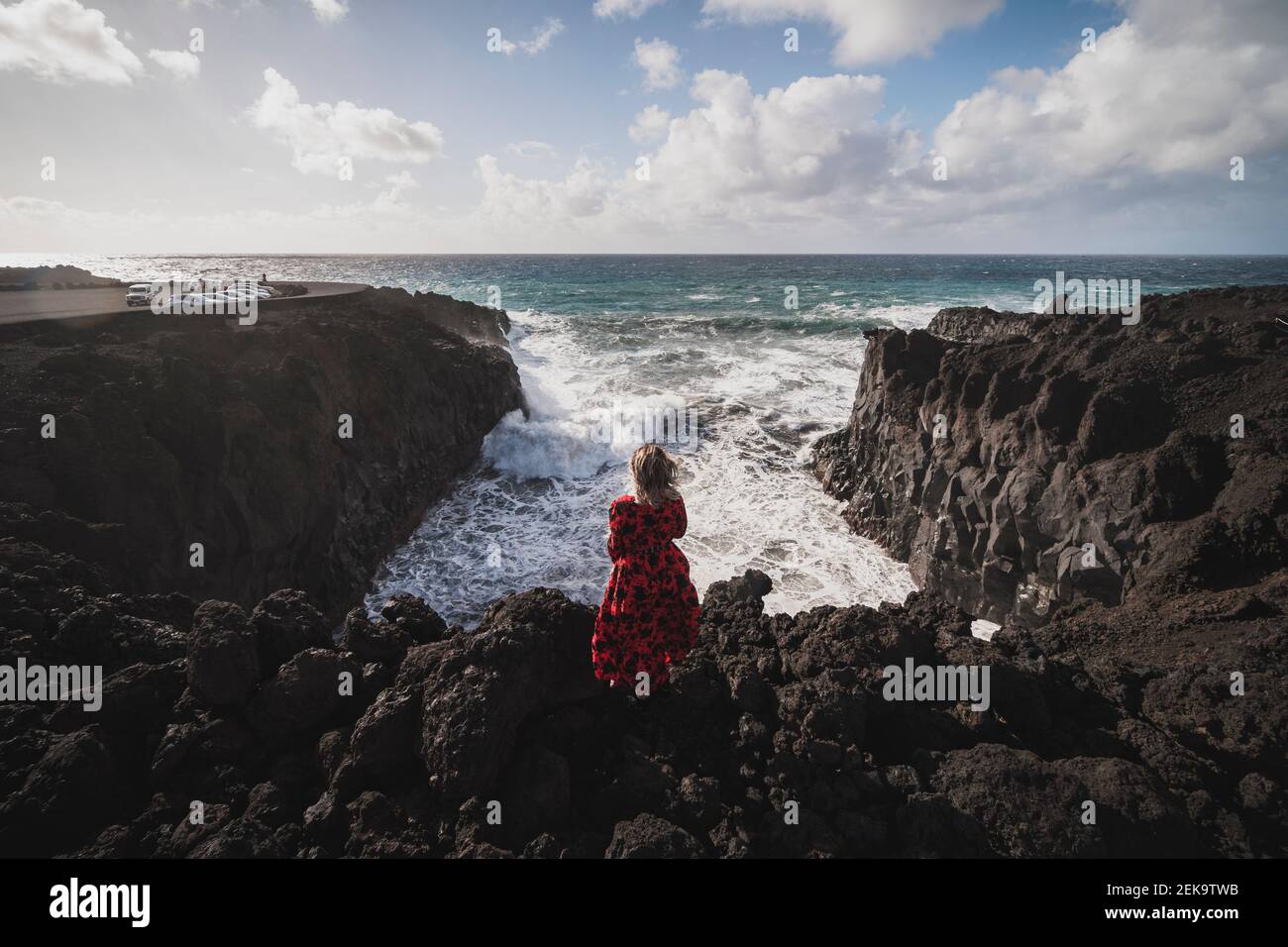 Femme regardant la vue sur la mer en se tenant sur la montagne à Los Hervideros, Lanzarote, Espagne Banque D'Images