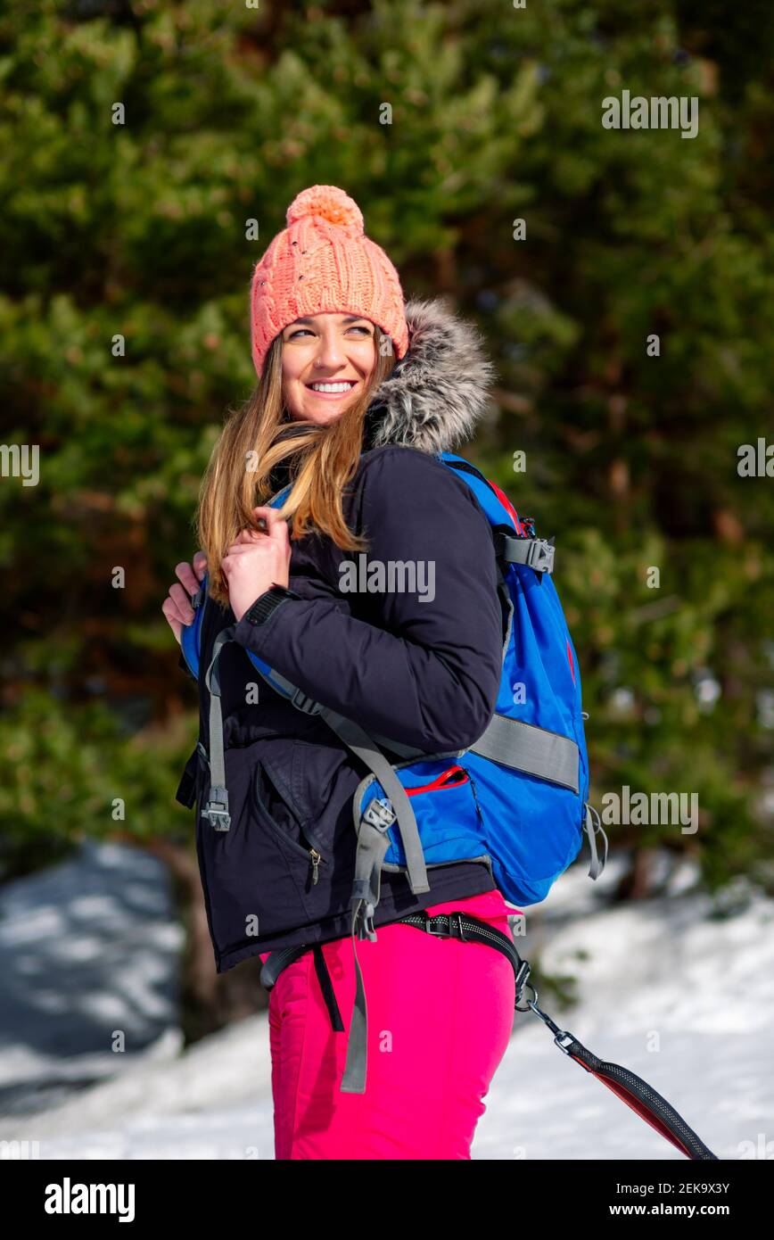 Femme souriante avec sac à dos à l'abri de l'hiver Banque D'Images
