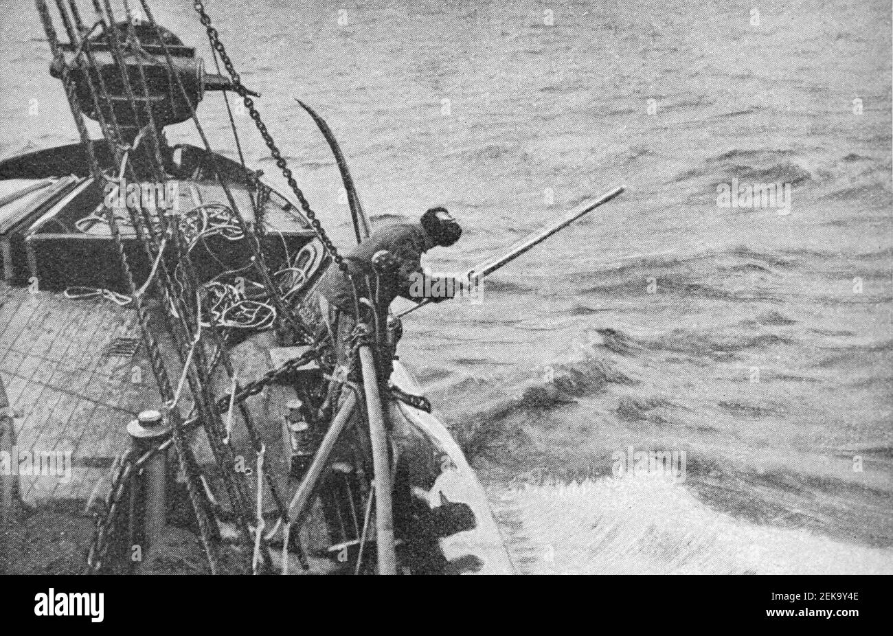 Photo du début du XXe siècle d'un homme coupant les fugues d'une carcasse de baleine morte à bord d'un navire de chasse à la baleine à Terre-Neuve-et-Labrador Canada. Photo de James Vey Banque D'Images