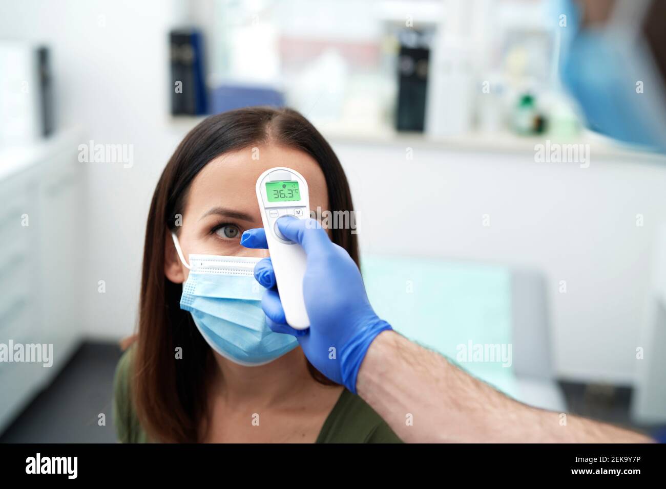 Patiente dont la température corporelle est correcte dans un thermomètre infrarouge à la clinique médicale Banque D'Images