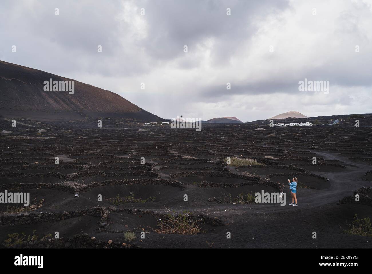 Femelle touriste explorant le vignoble au volcan El Cuervo, Lanzarote, Espagne Banque D'Images