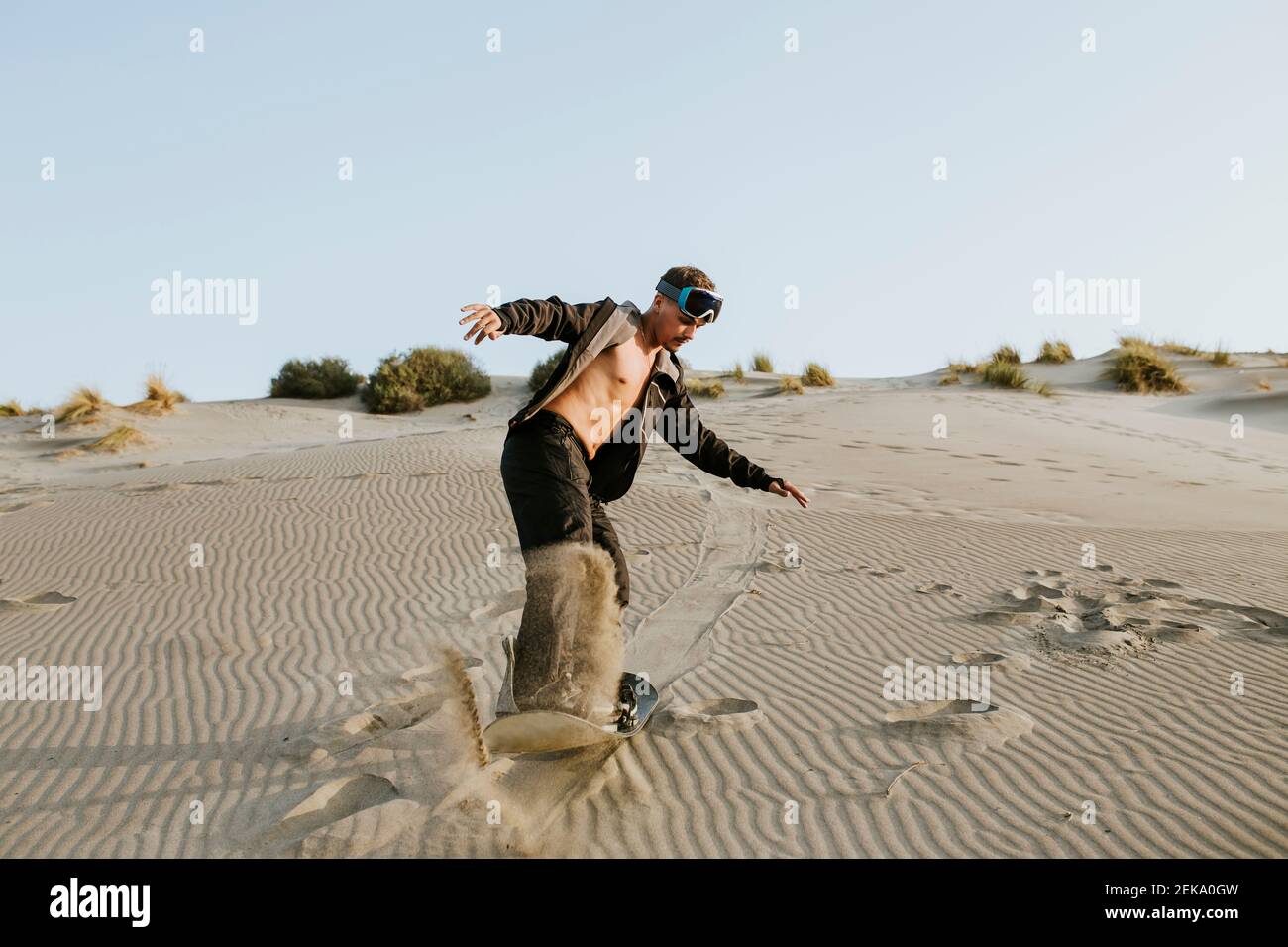 Un jeune homme qui s'embarque sur le sable à Almeria, désert de Tabernas, Espagne Banque D'Images