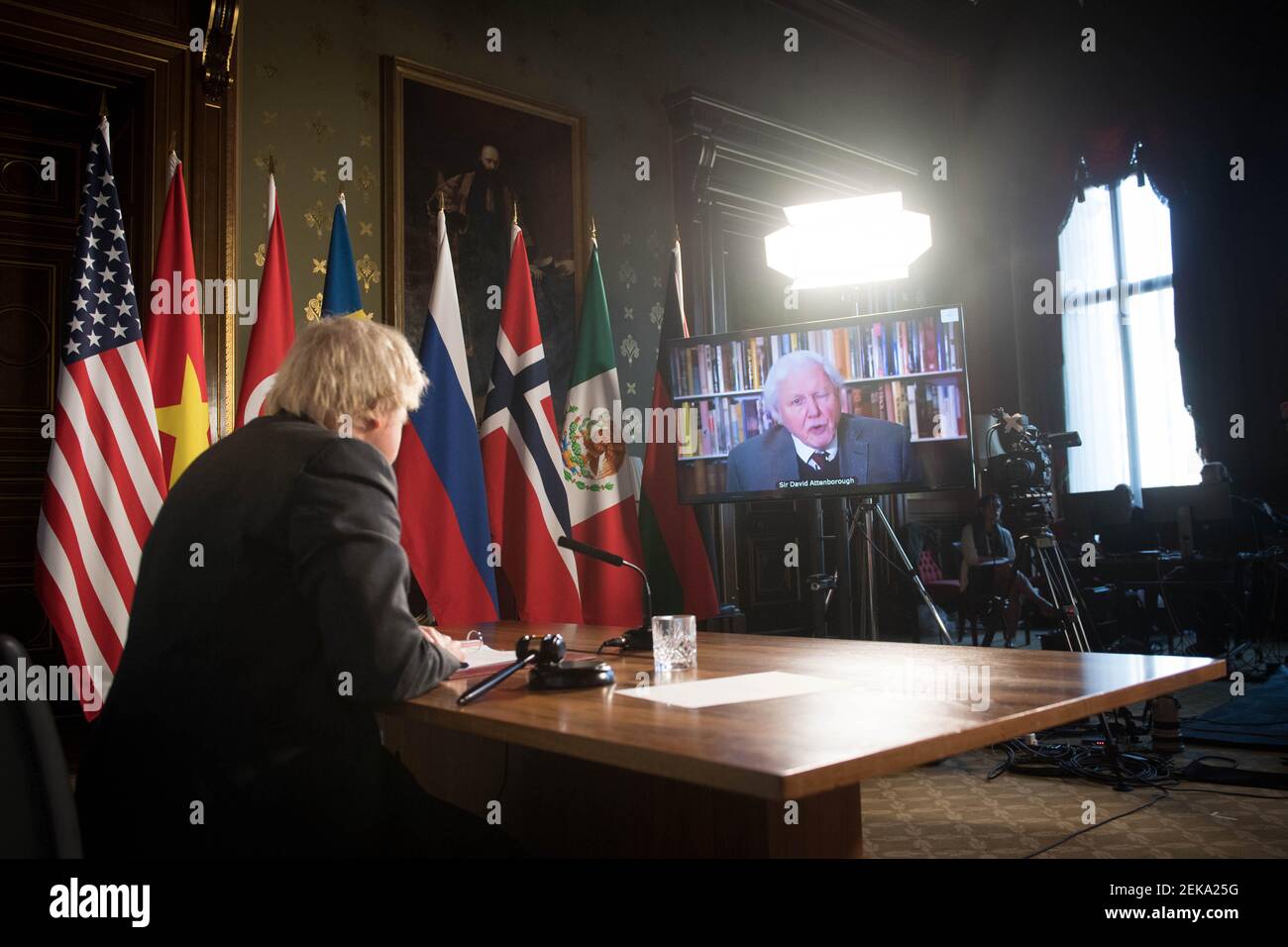 Le Premier ministre Boris Johnson regarde un discours vidéo de Sir David Attenborough lors d'une session du Conseil de sécurité des Nations Unies sur le climat et la sécurité au Bureau des affaires étrangères, du Commonwealth et du développement à Londres. Date de la photo: Mardi 23 février 2021. Banque D'Images