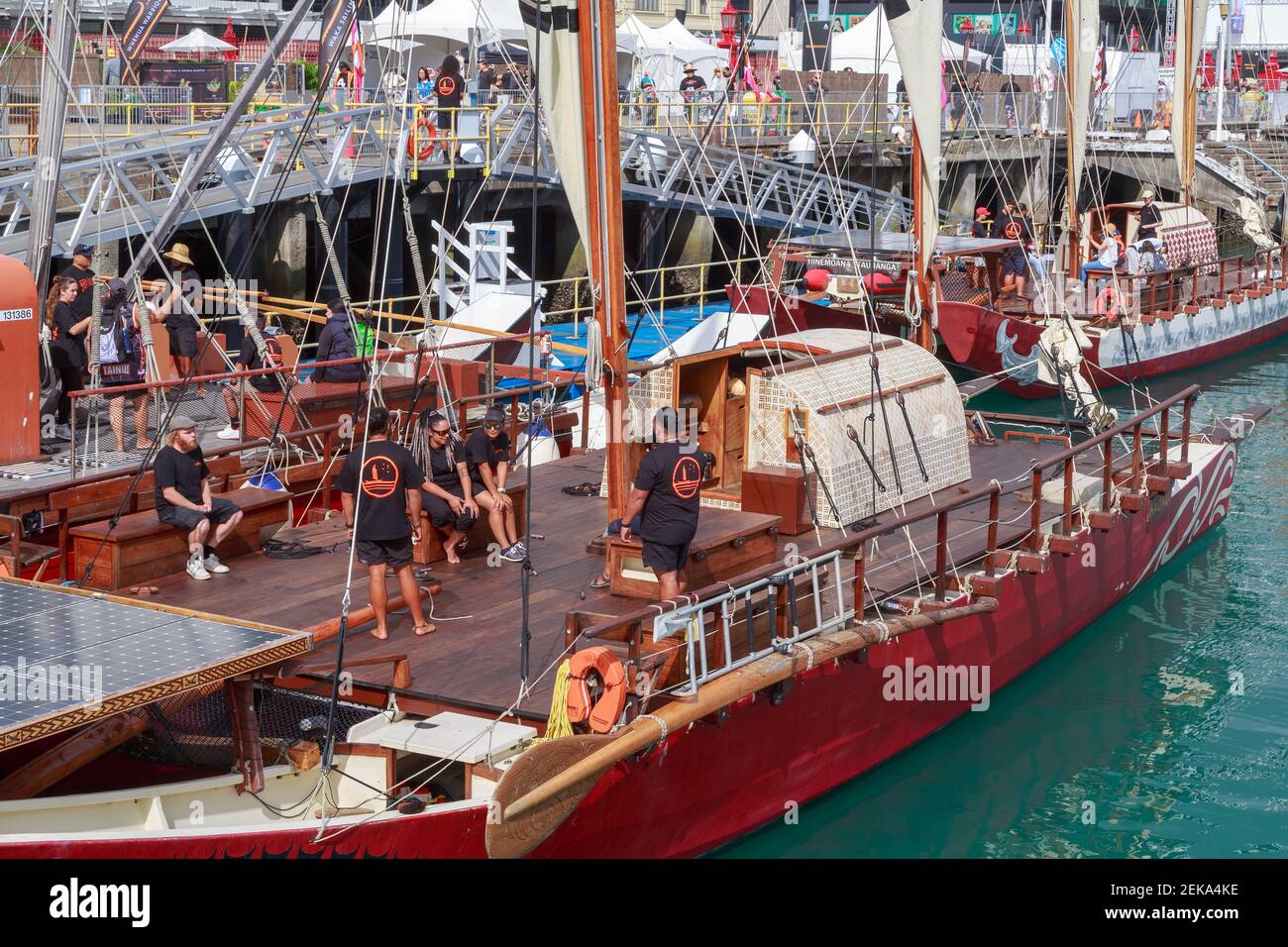 Des gens sur le pont d'un traditionnel vaka moana polynésien, un grand canoë sur l'océan, au Tamaki Herenga Waka Festival, Auckland, Nouvelle-Zélande Banque D'Images