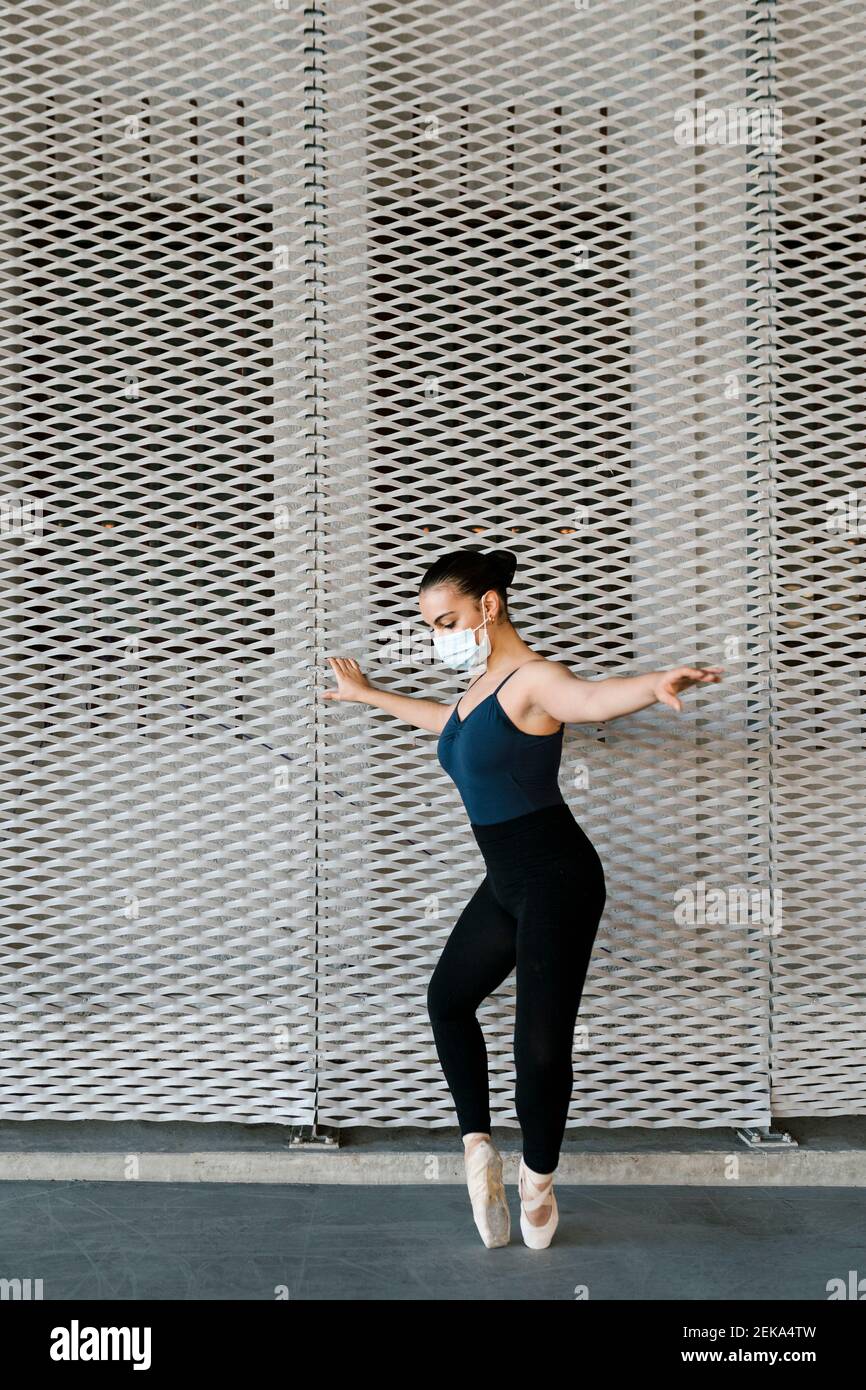 Femme avec masque facial protecteur pratiquant la danse de ballet par le  métal mur Photo Stock - Alamy