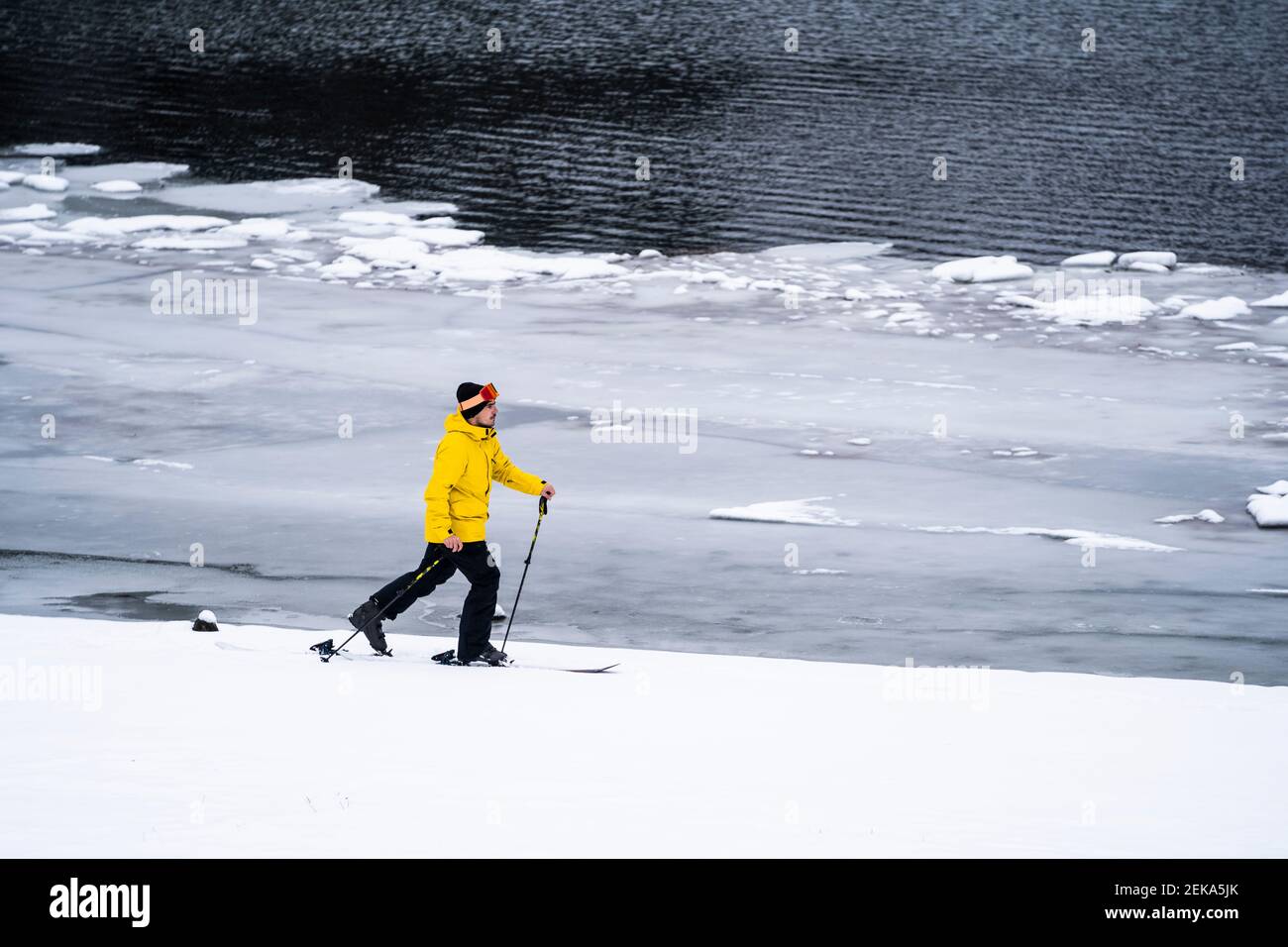 Homme ski au bord du lac en hiver Banque D'Images