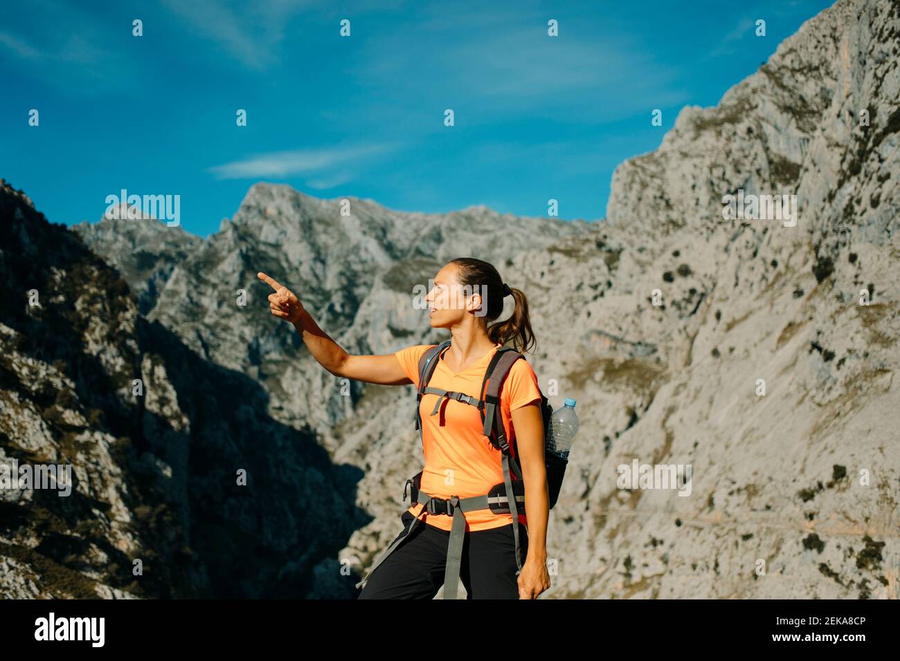 Femme adulte de taille moyenne en faisant des gestes contre la chaîne de montagnes à Cares Trail dans le parc national de Picos de Europe, Asturies, Espagne Banque D'Images