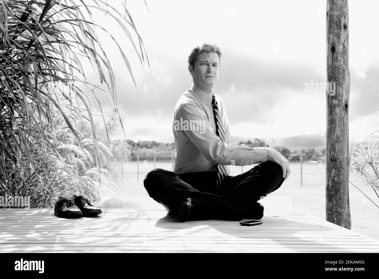 Businessman doing yoga dans un parc Banque D'Images