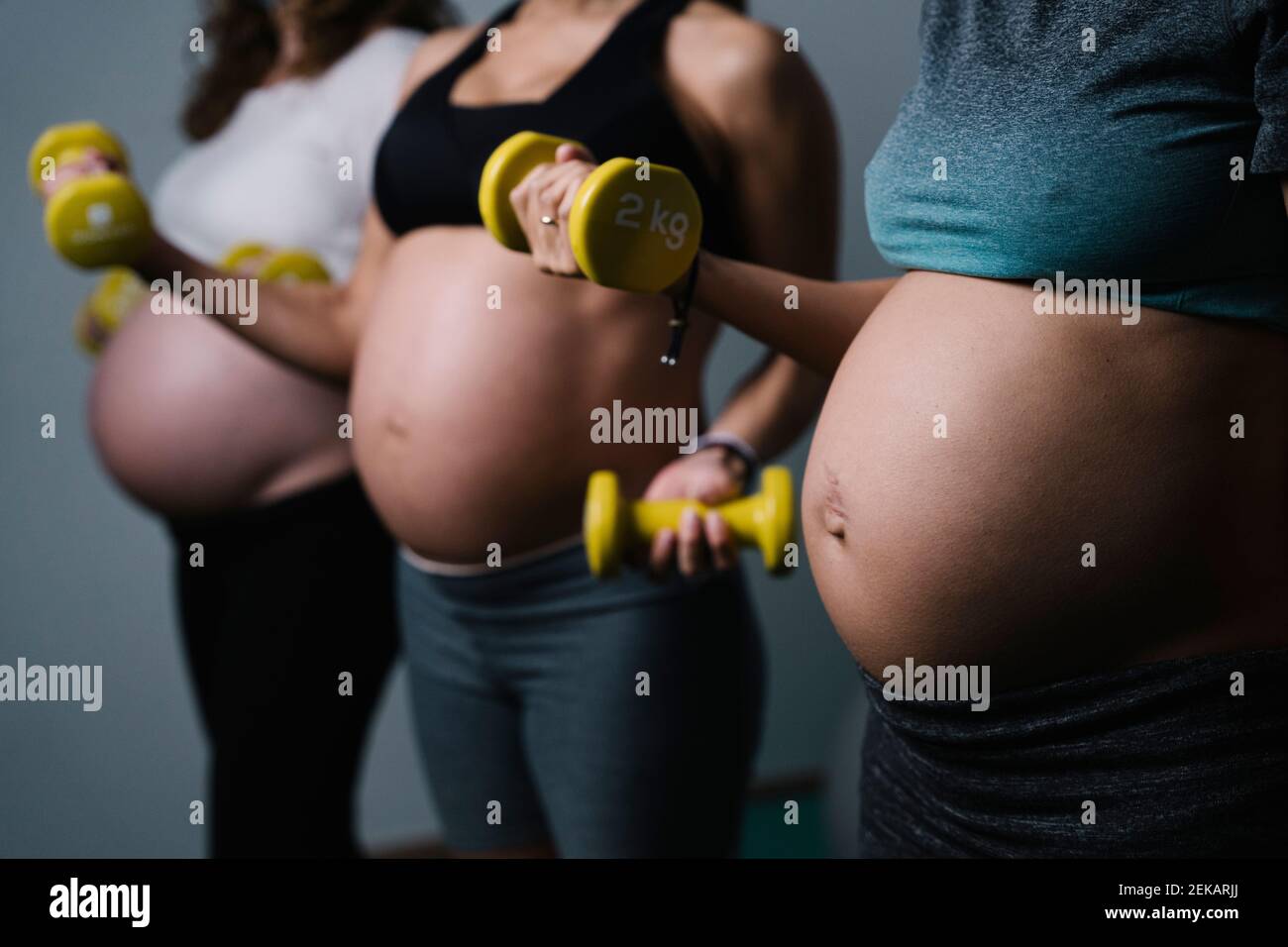 Femmes enceintes avec haltères Banque D'Images