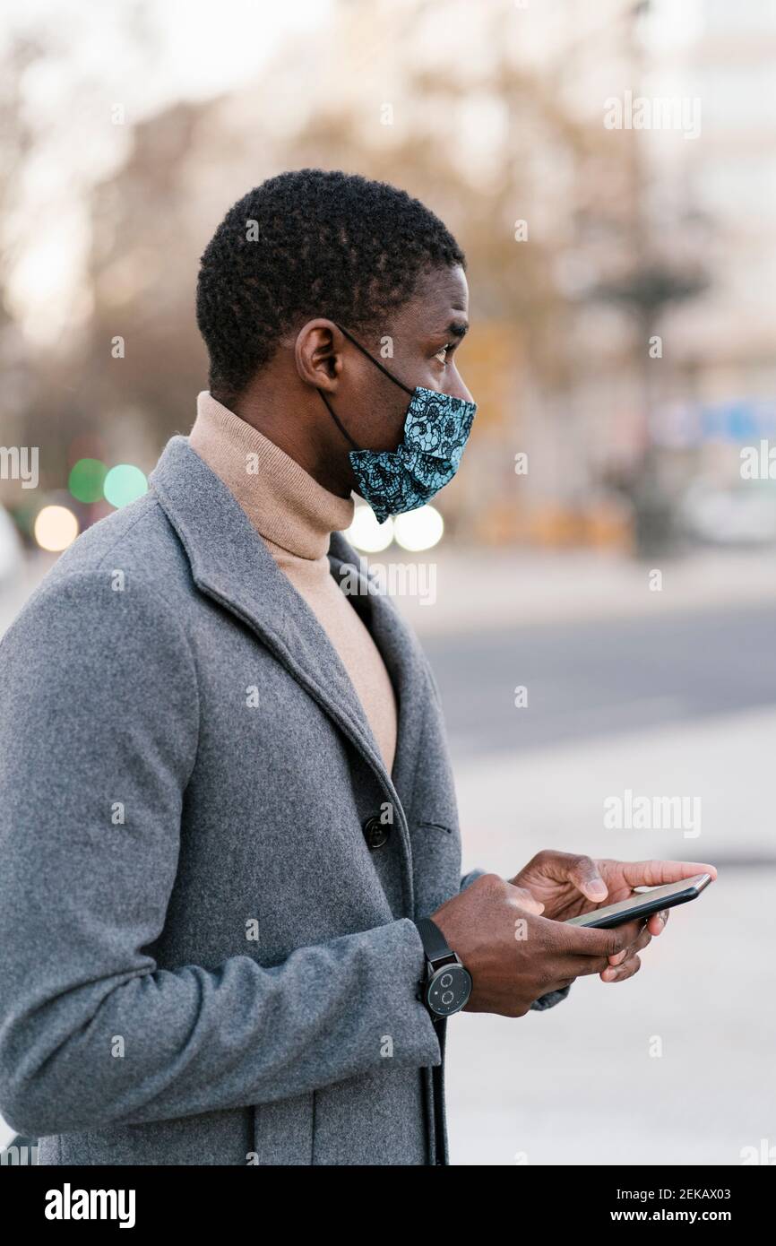 Un homme portant un masque facial avec son smartphone la neige abondante d' hiver dans une tempête d'hiver à Toronto, Canada Photo Stock - Alamy