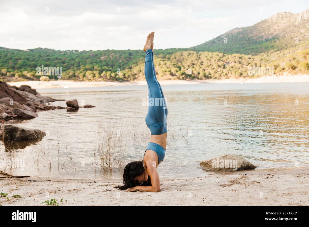 Jeune femme faisant du yoga Pincha Mayurasana Banque D'Images