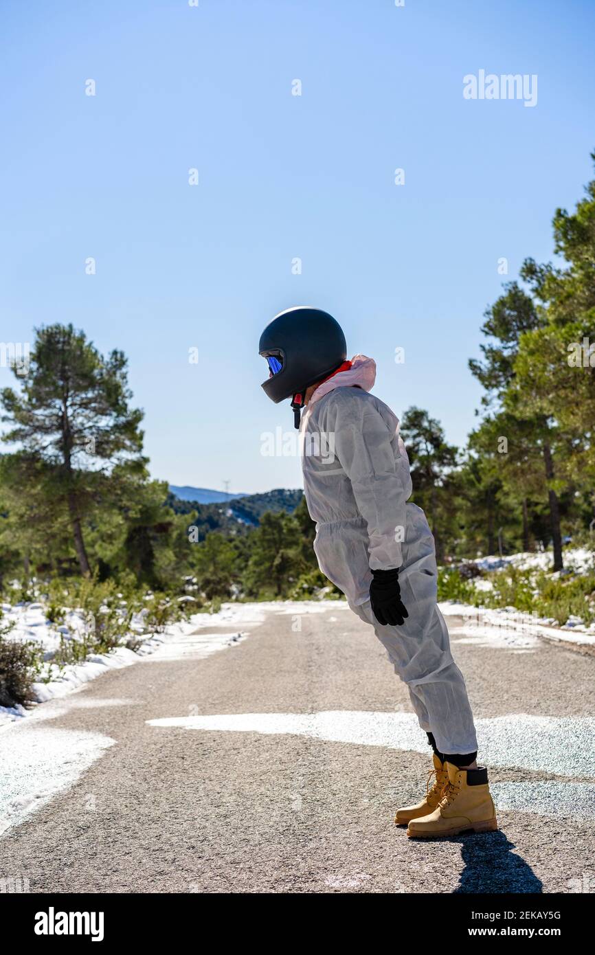 Homme portant des vêtements de ski et des lunettes de protection en regardant loin en étant debout route Banque D'Images