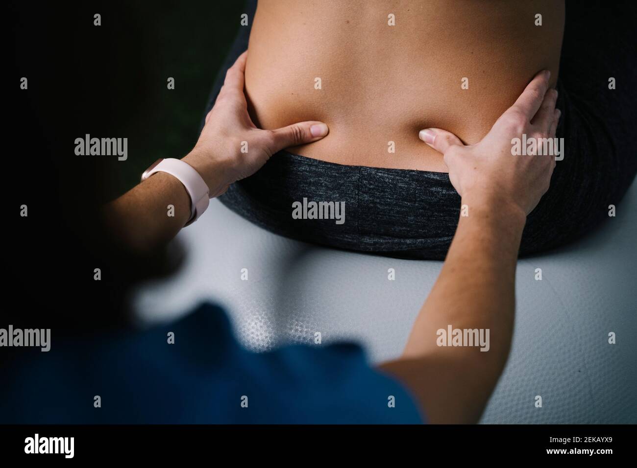Sage-femme massant le dos de la femme enceinte Banque D'Images