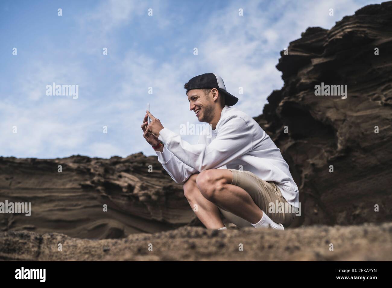 Souriant homme touriste par smartphone à El golfo, Lanzarote, Espagne Banque D'Images