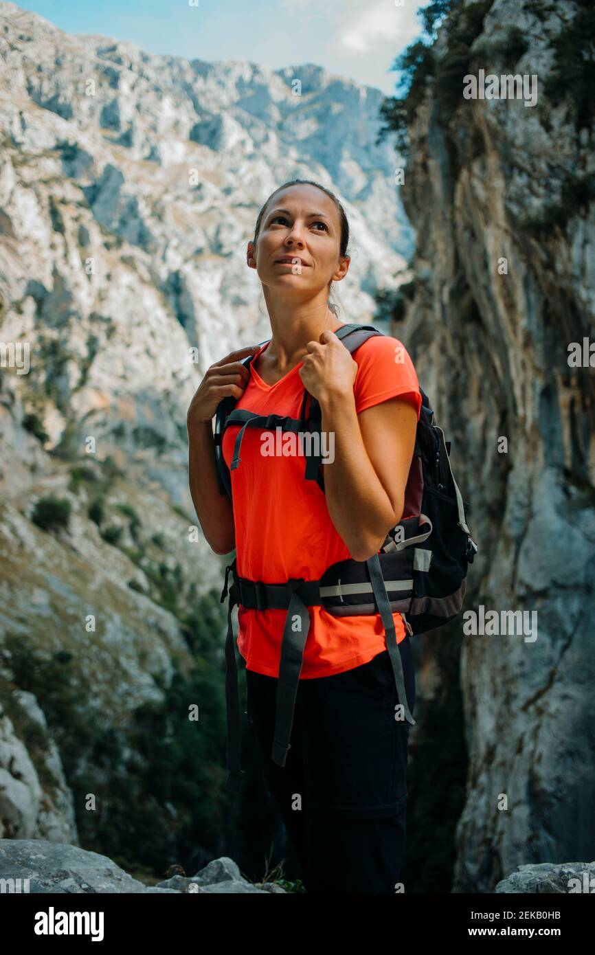 Femme explorer avec sac à dos en regardant à l'écart tout en se tenant à CARES Trail dans le parc national de Picos de Europe, Asturies, Espagne Banque D'Images
