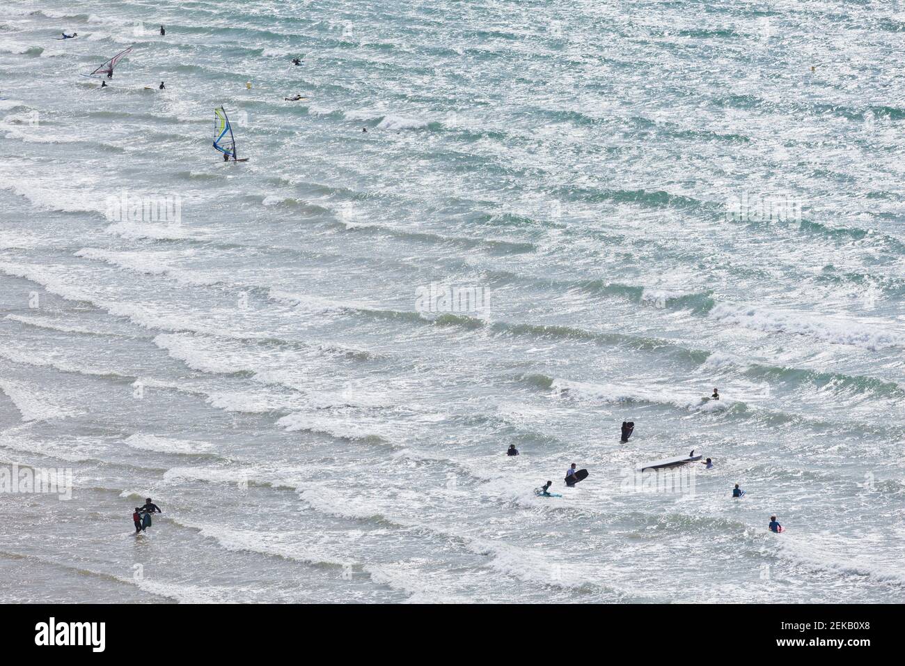 AM Strand von Erquy in der Bretagne nutzen Surfer die ankommenden Wellen. Banque D'Images