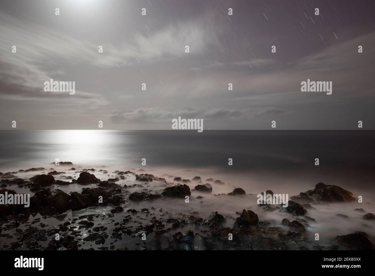 Nuages et Lune au-dessus de la mer la nuit Banque D'Images