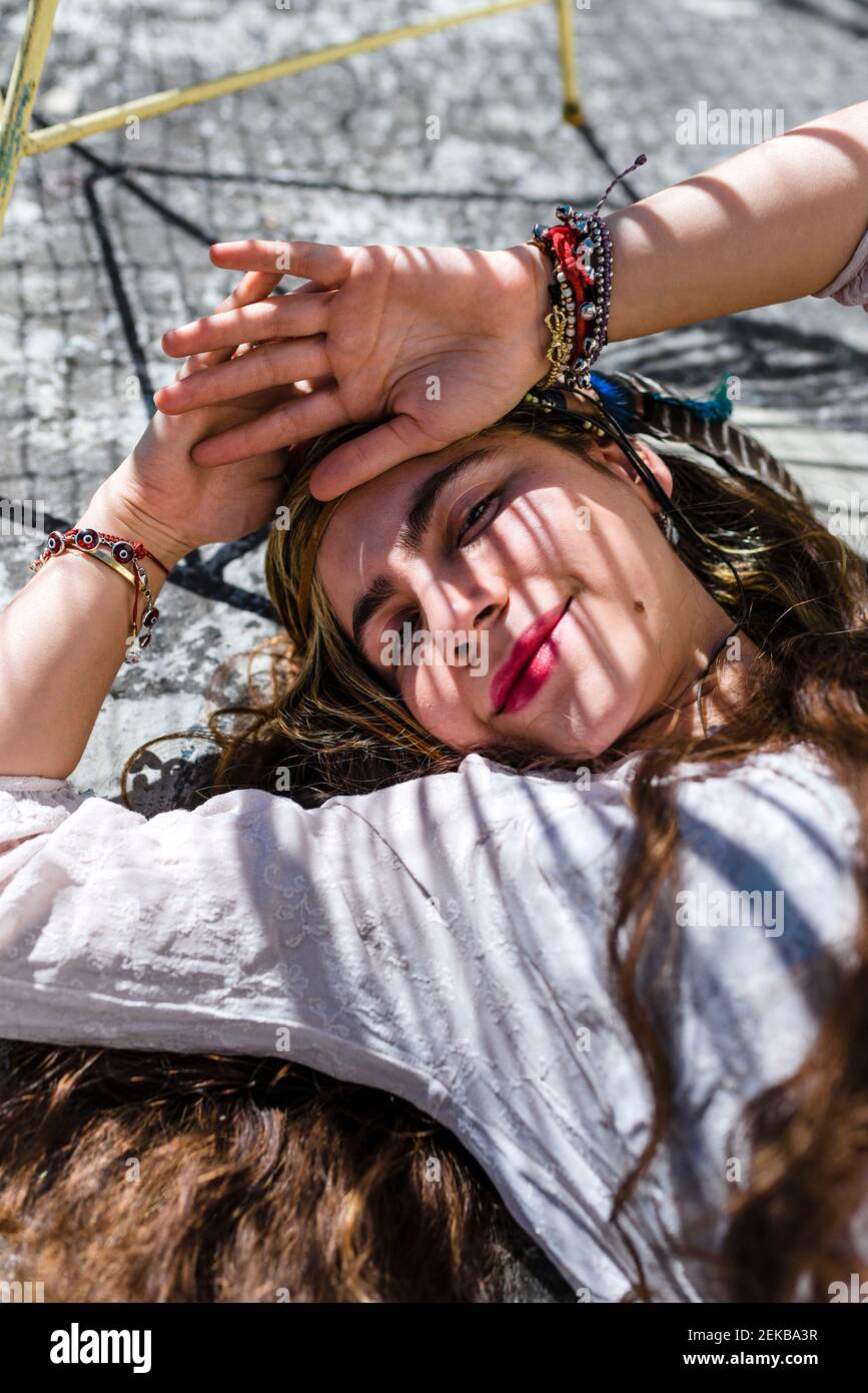 Hippie belle femme avec de longs cheveux dormant sur un sol en béton Banque D'Images