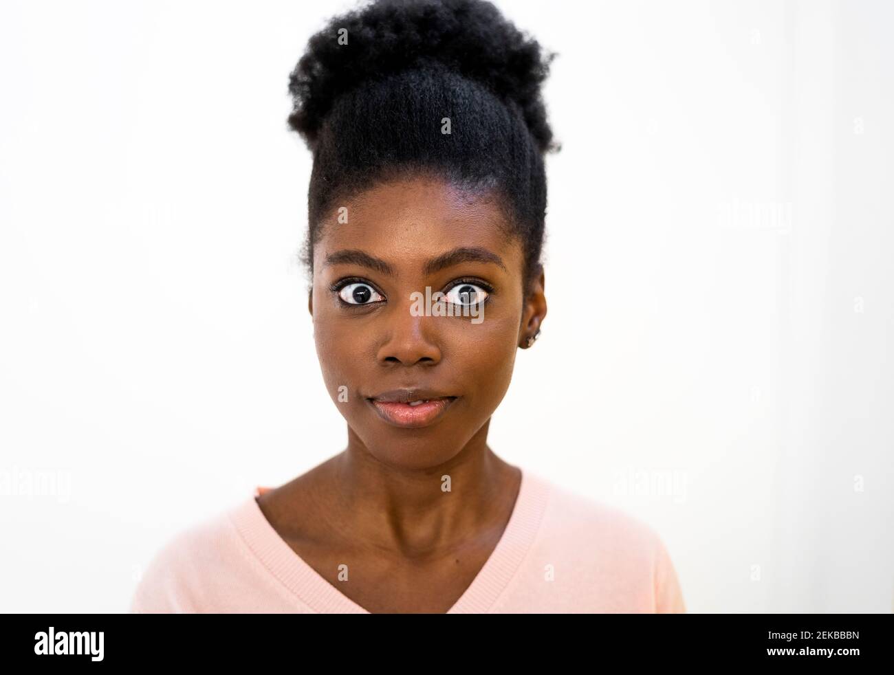 Surpris femme regardant en se tenant sur fond blanc Banque D'Images