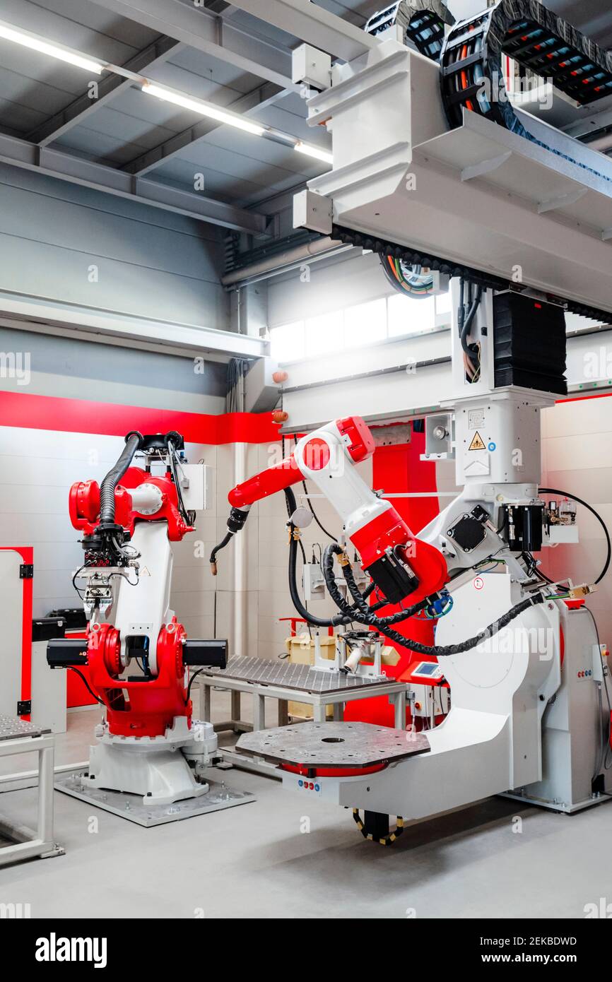 Robots de soudage modernes dans le bâtiment industriel Banque D'Images