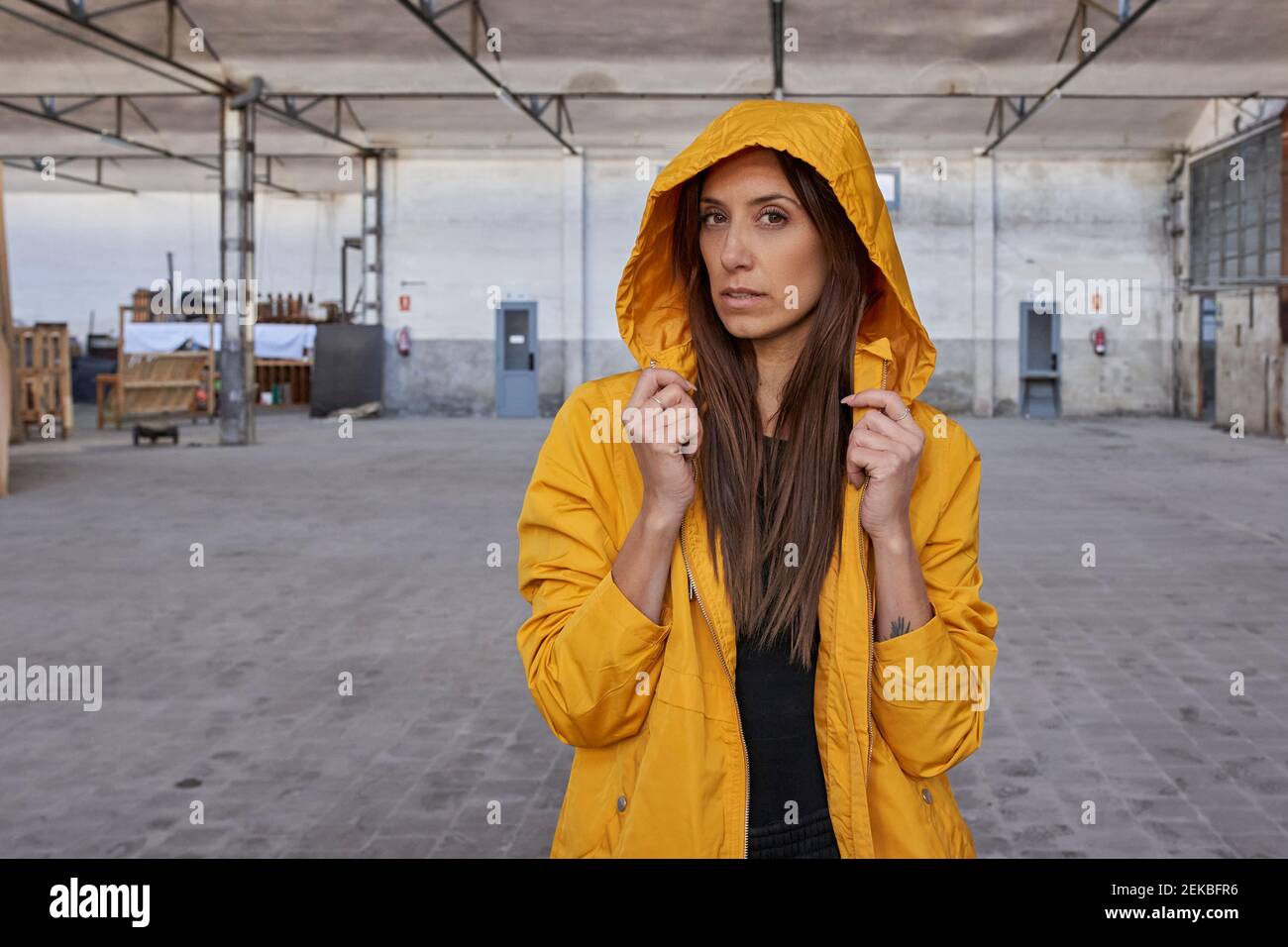 Danseuse moderne avec de longs cheveux dans la veste jaune à l'abandon usine Banque D'Images