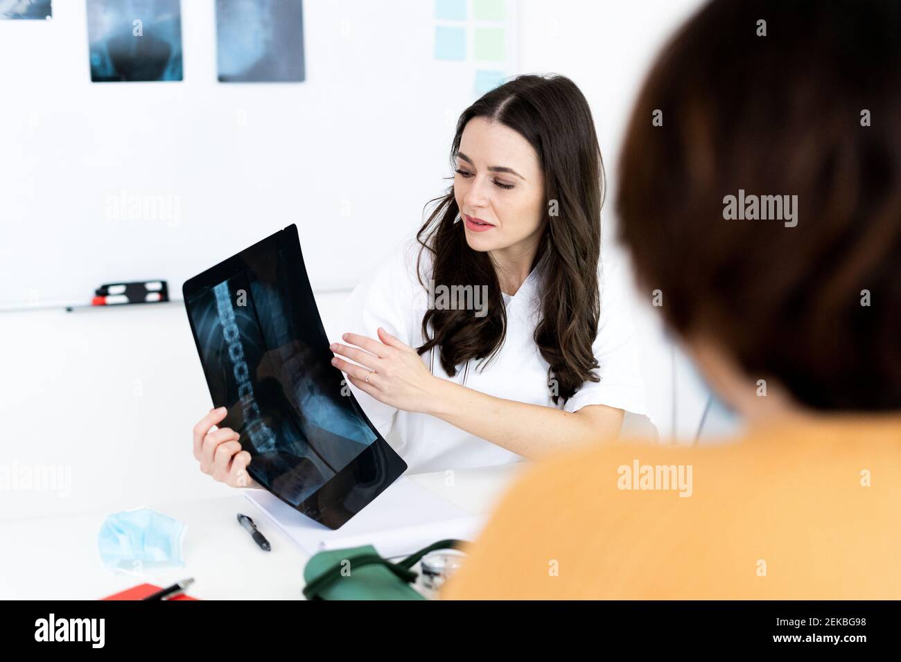 Le patient prend conseil auprès d'un médecin féminin tout en affichant une image radiologique à la clinique médicale Banque D'Images
