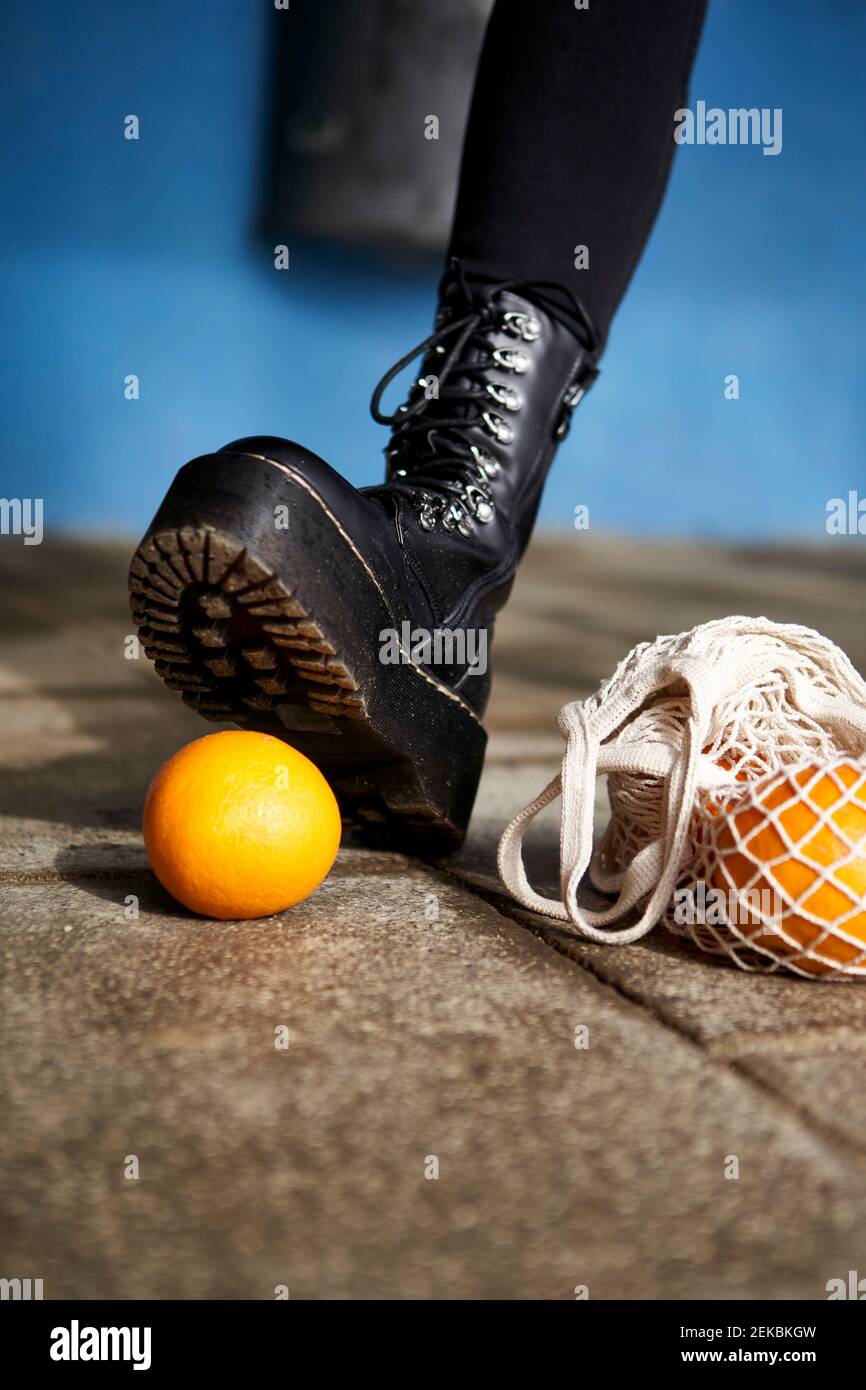Femme pied sur un fruit orange sur la piste de marche Banque D'Images