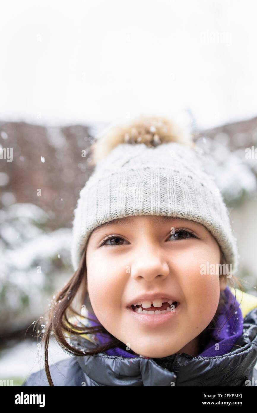 Jolie fille avec les yeux fermés collant hors de la langue pendant l'hiver Banque D'Images