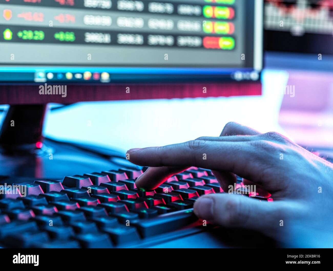 Mains de Trader tapant sur le clavier devant l'ordinateur surveiller l'affichage des données boursières Banque D'Images