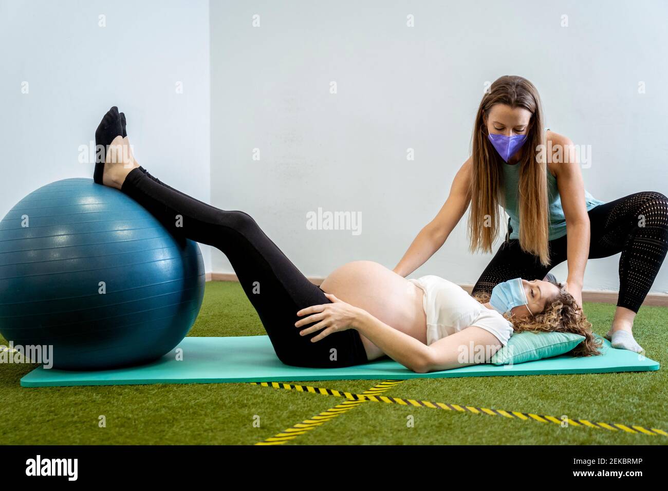 Femme enceinte allongée sur un tapis d'exercice Banque D'Images