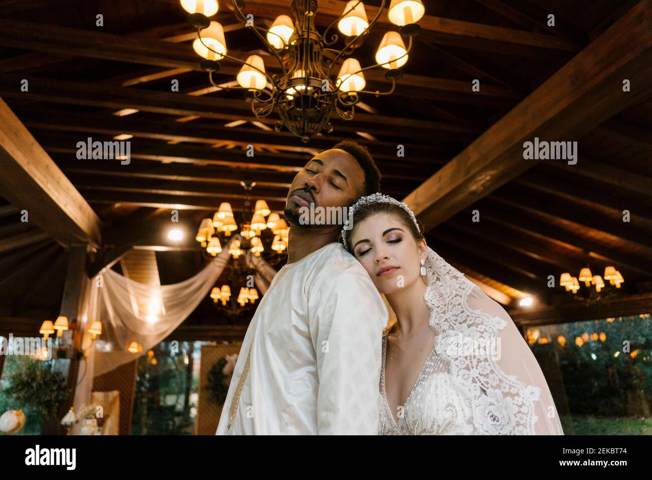 Mariée et marié vêtu d'une robe de mariage penchée l'une sur l'autre pendant le banquet Banque D'Images