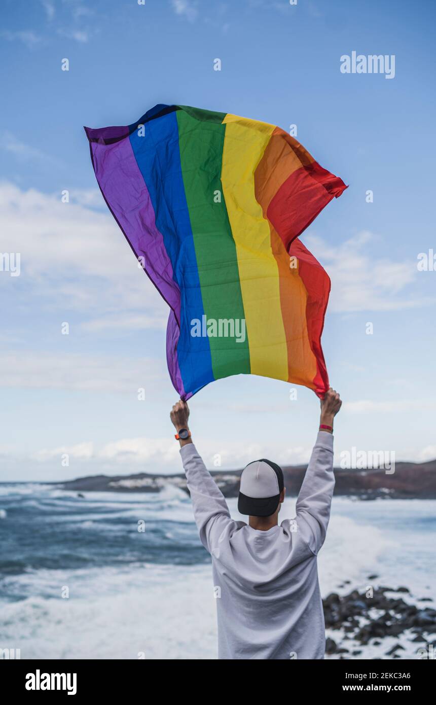 Homme de tourisme tenant LGBTQI drapeau à El golfo pendant les vacances, Lanzarote, Espagne Banque D'Images