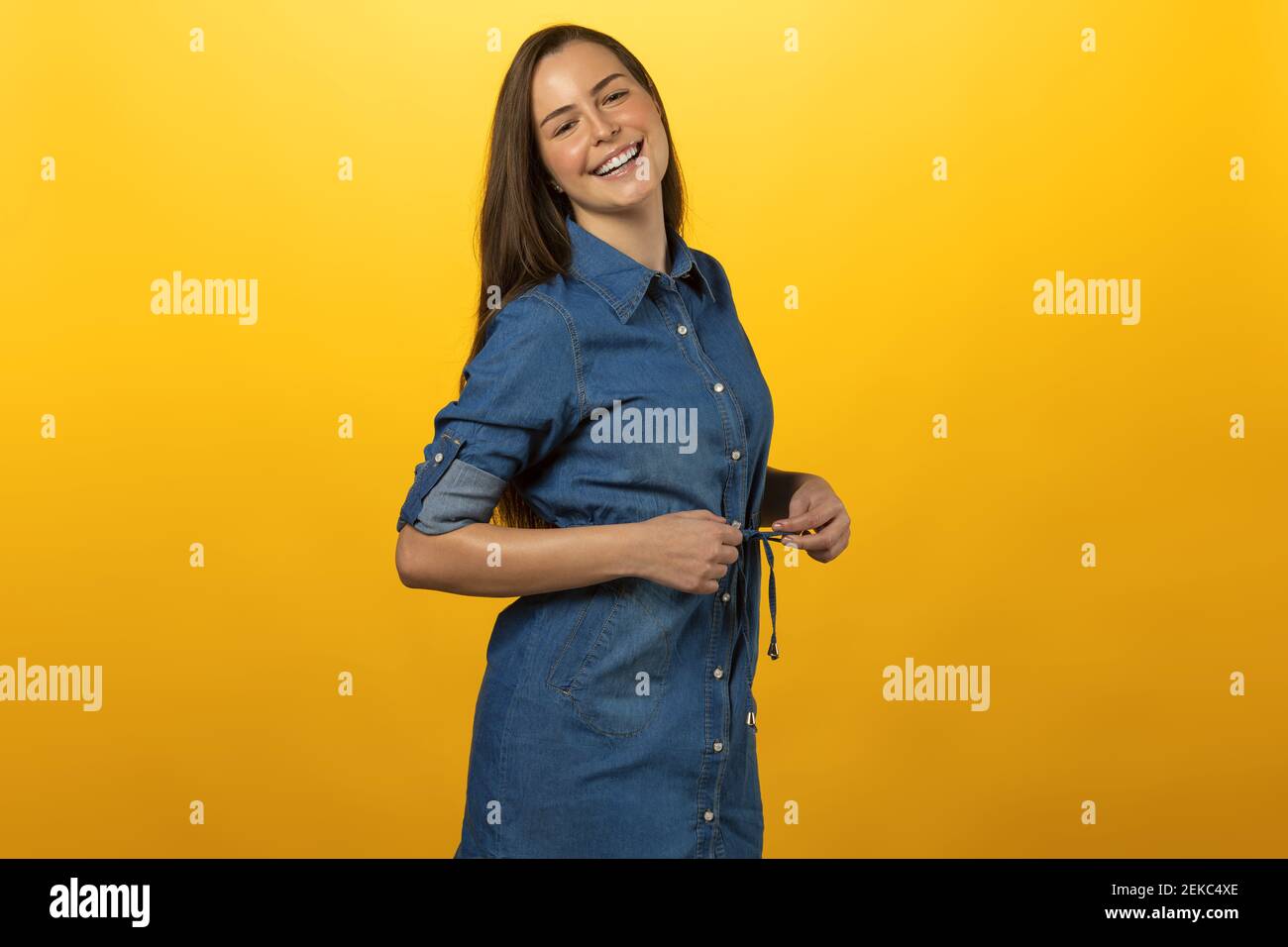 portrait frais d'une jeune fille beauté en bleu jeans ensemble. regardant dans l'appareil photo avec le sourire . sur jaune. concept de bonheur Banque D'Images
