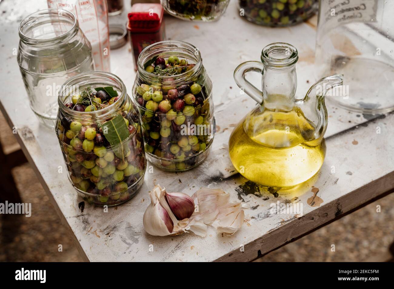 Pots en verre remplis d'olives et d'ail conservés sur la table Banque D'Images