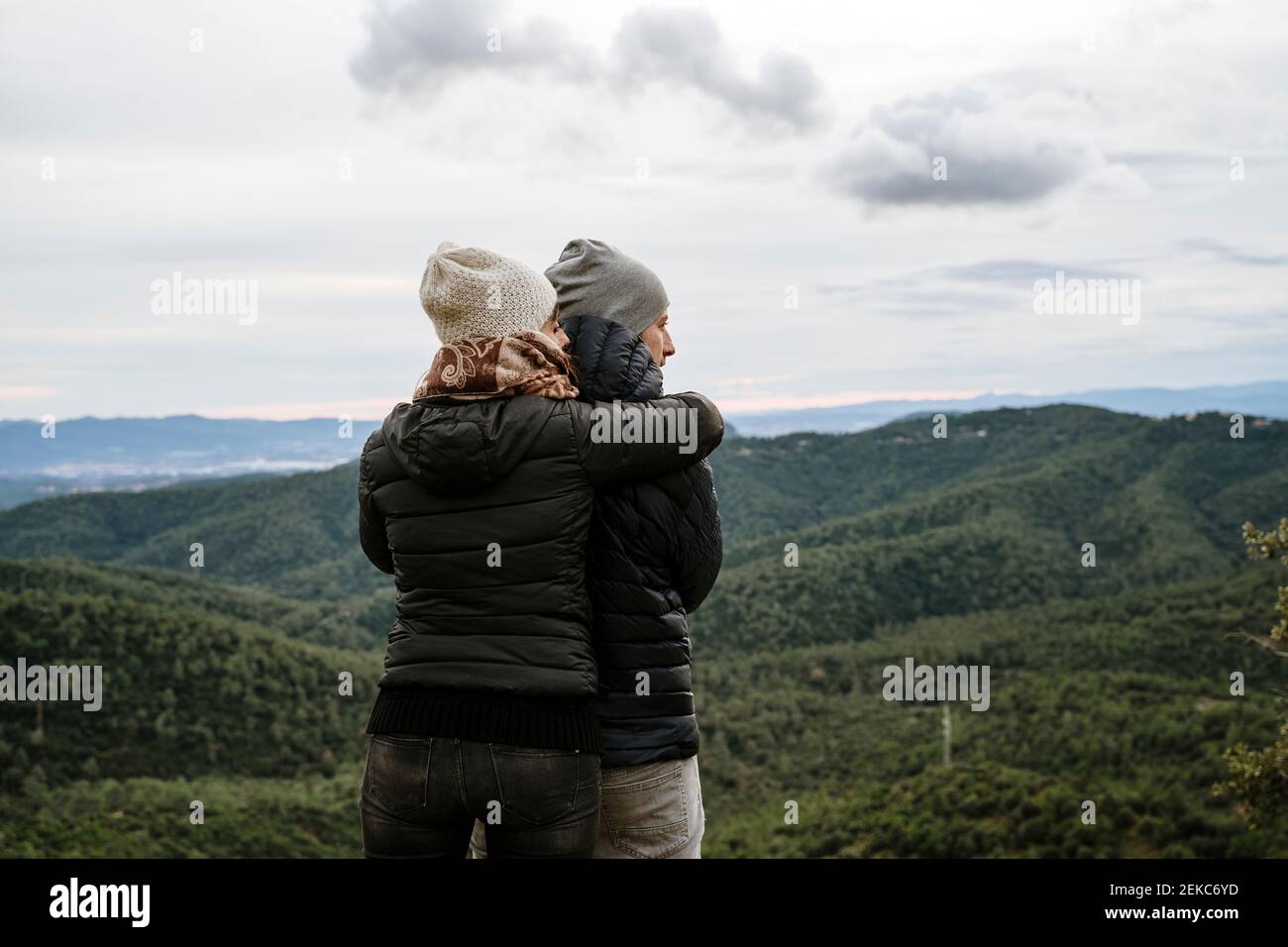 Couple touristique s'embrassant les uns les autres en regardant loin en se tenant à point de vue Banque D'Images