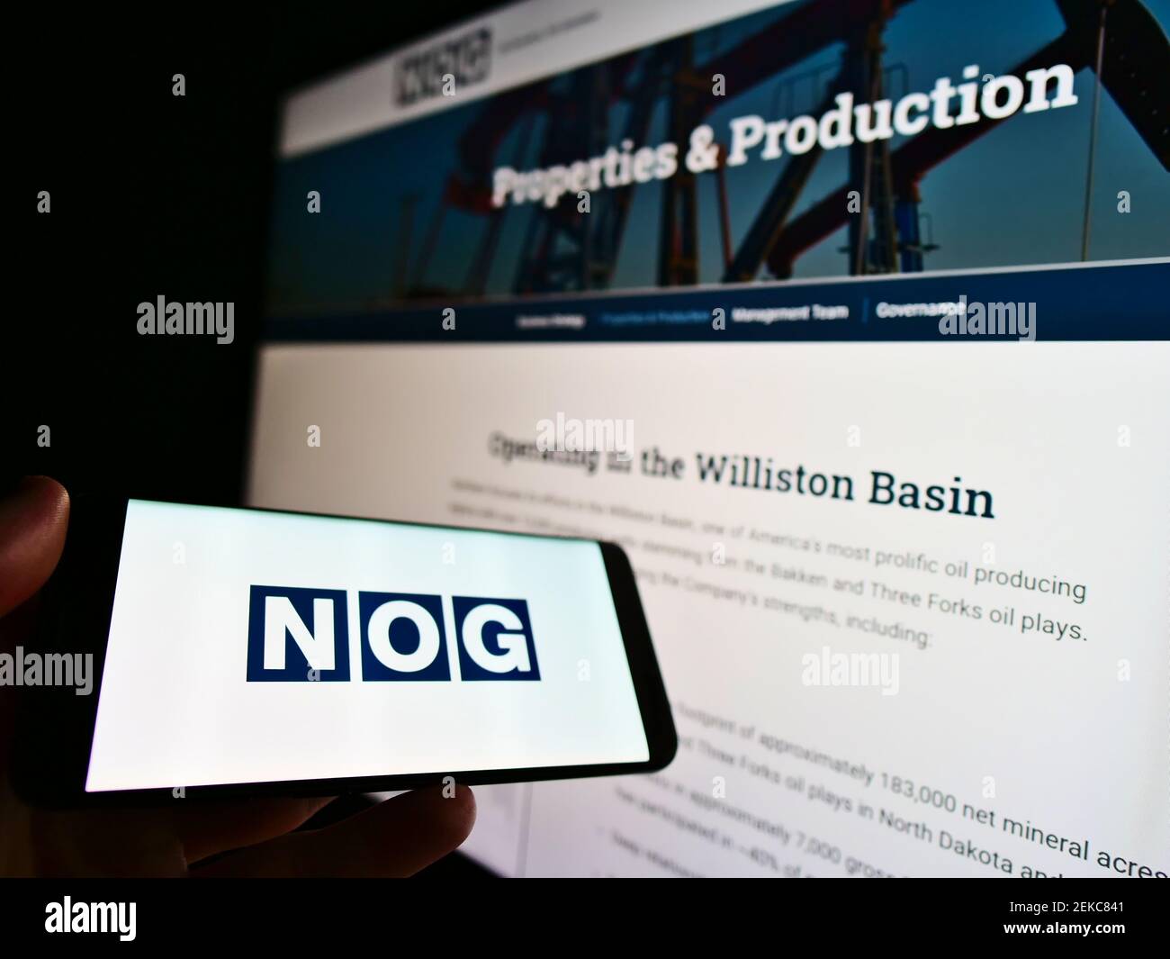 Personne tenant un téléphone portable avec le logo de la société américaine d'énergie Northern Oil and Gas (NOG) sur l'écran devant le site Web d'affaires. Mise au point sur l'affichage du téléphone. Banque D'Images