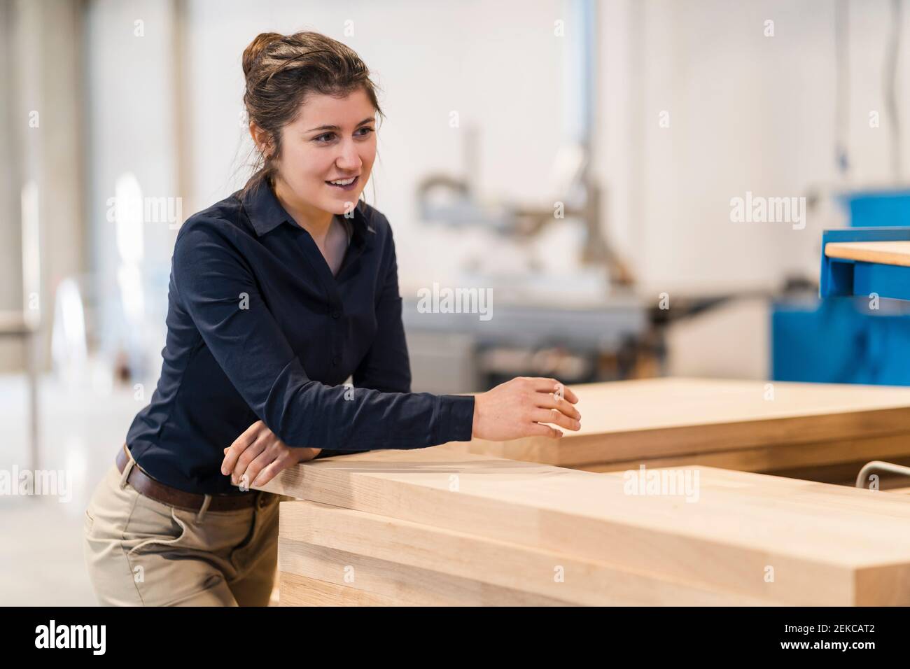 Jeune femme d'affaires souriant en se tenant dans l'industrie Banque D'Images