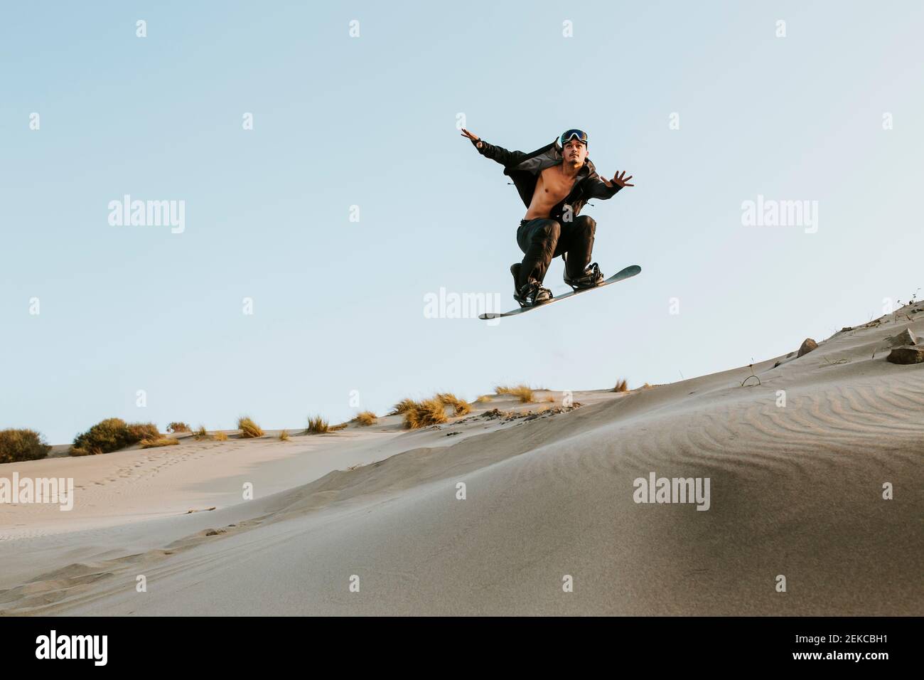 Jeune homme effectuant des cascades tout en standboarding à Almeria, désert de Tabernas, Espagne Banque D'Images