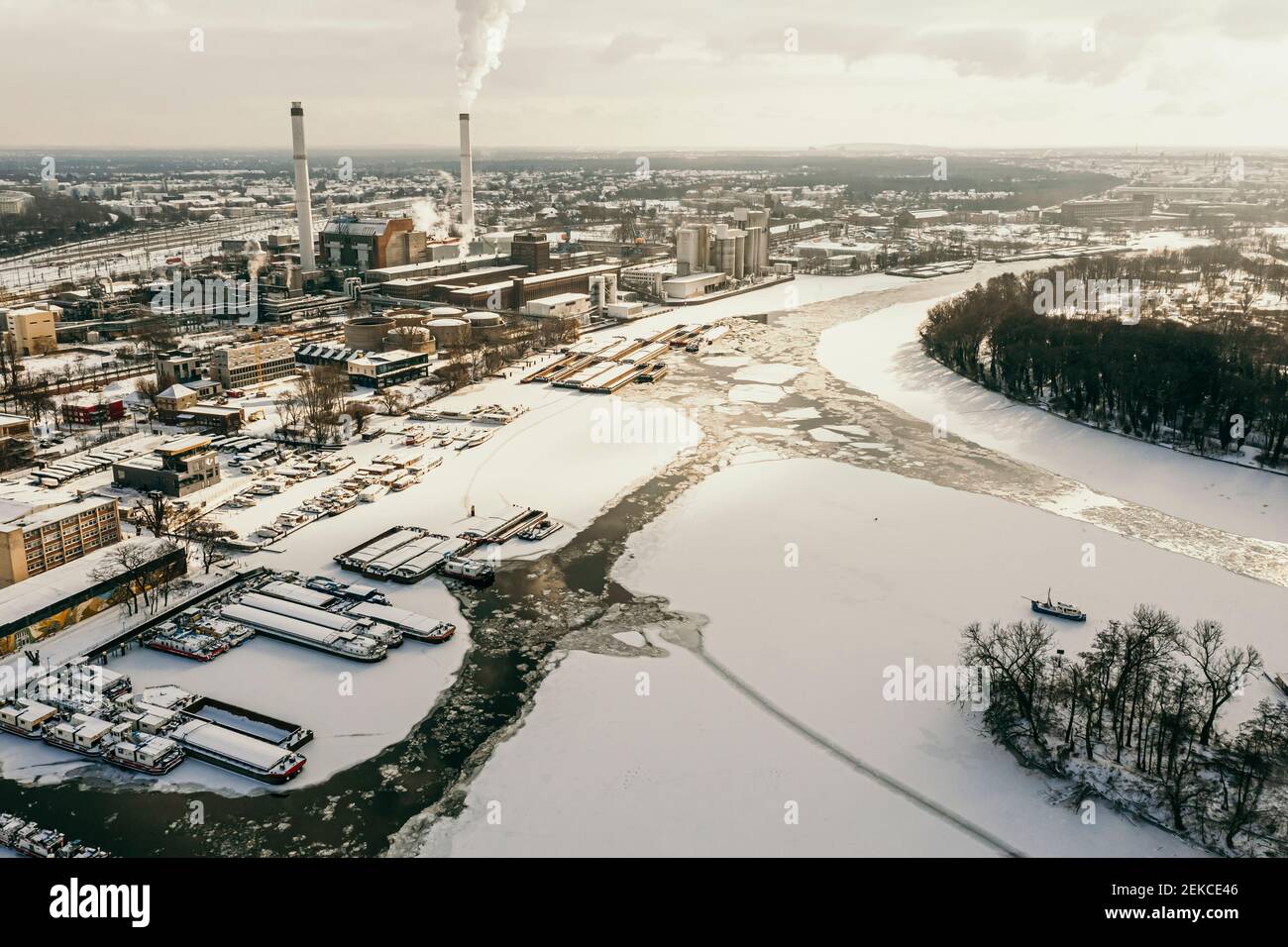 Allemagne, Berlin, cheminée de la centrale électrique de fumeurs dominant la rivière Spree gelée Banque D'Images