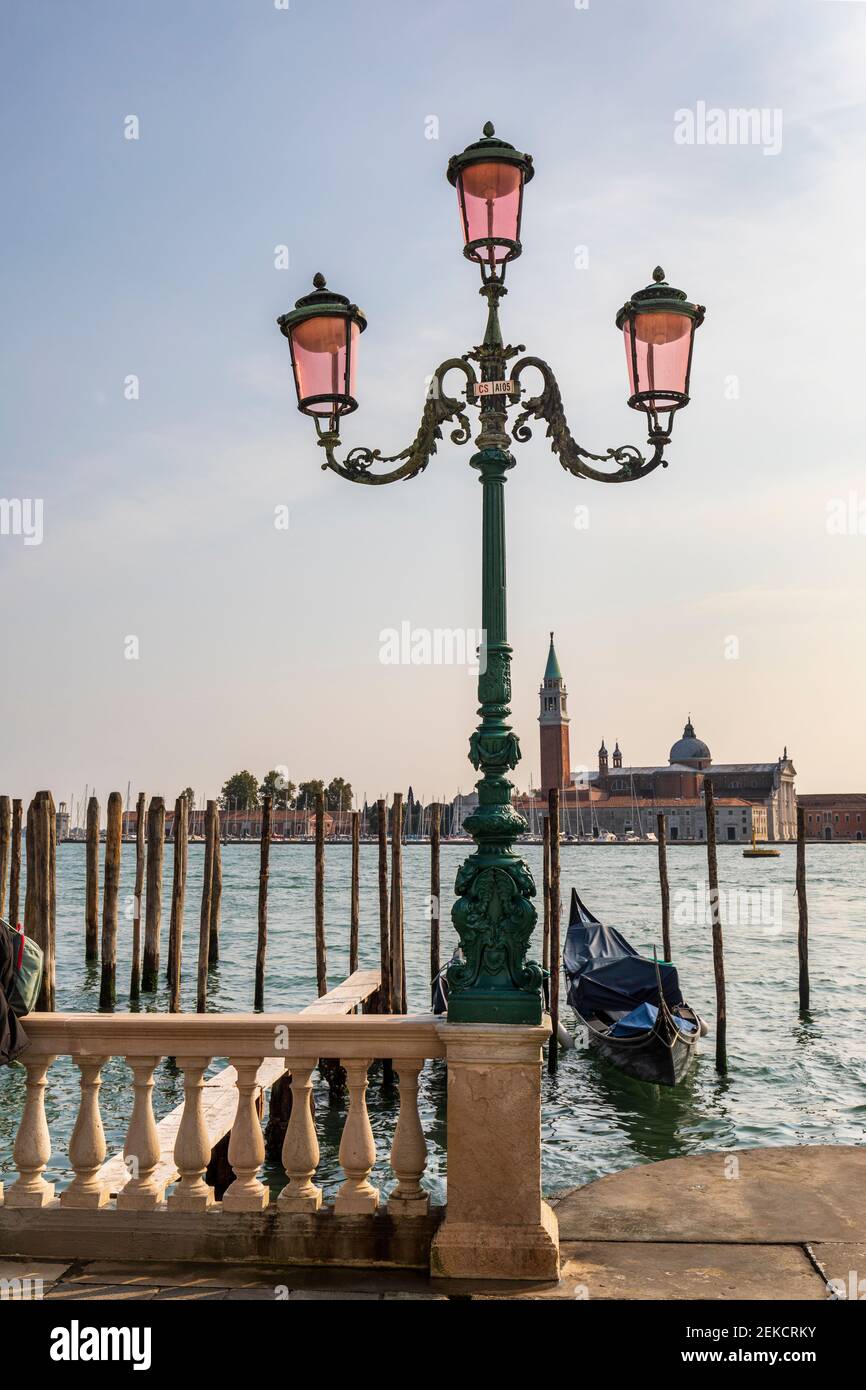 Lampadaire vénitien vert orné avec lampes en verre rose. Gondolier et  église San Giorgio Maggiore en arrière-plan, Venise, Italie Photo Stock -  Alamy