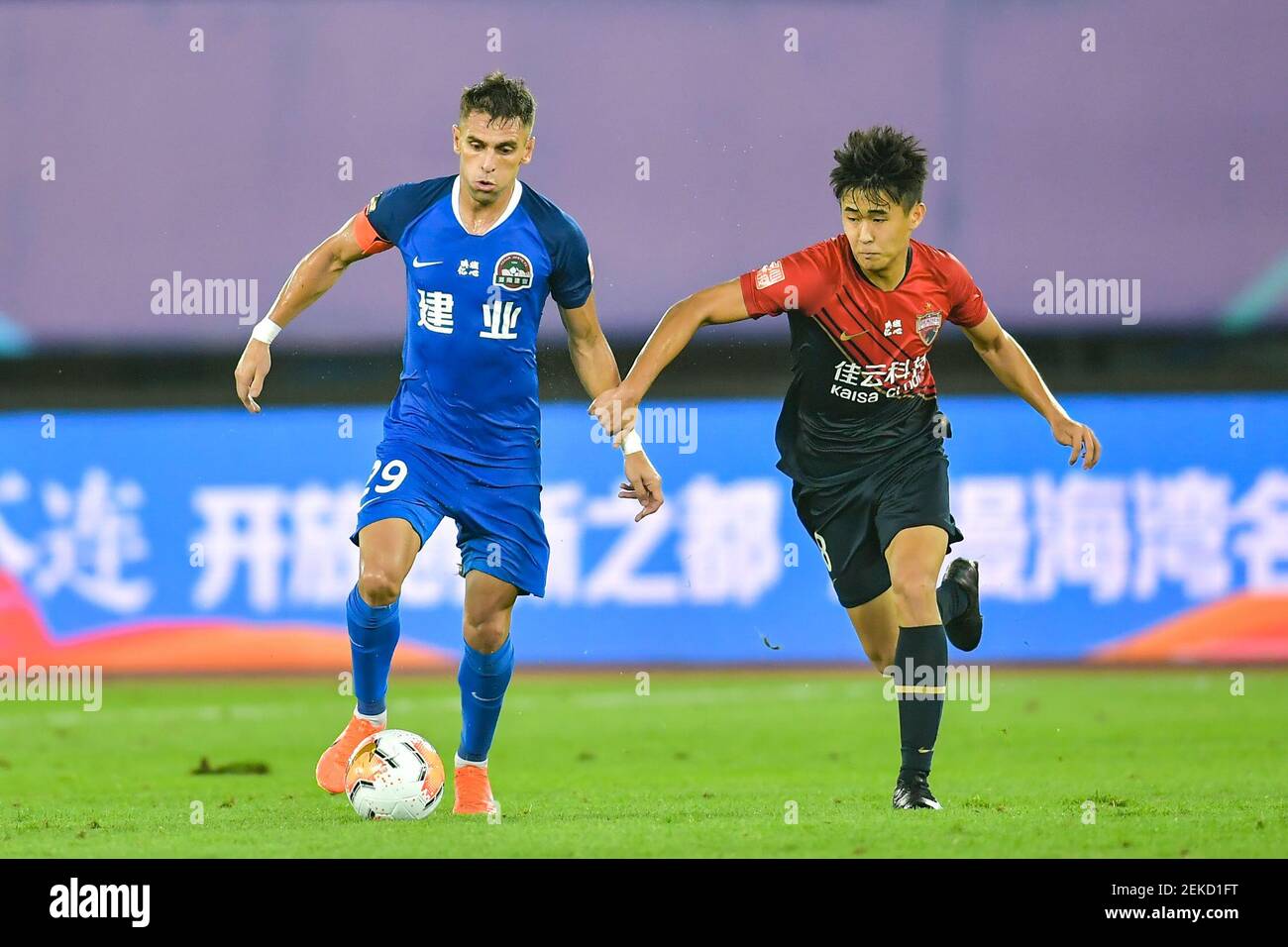 Le joueur brésilien de football Olivio da Rosa, également connu sous le nom d'Ivo, de Henan Jianye F.C., à gauche, protège le ballon lors du quatrième tour de la Super League chinoise (CSL) 2020 contre Shenzhen F.C., Dalian ville, province de Liaoning au nord-est de la Chine, 10 août 2020. Le F.C. Shenzhen a été battu par le F.C. Henan Jianye avec 1-2. Banque D'Images