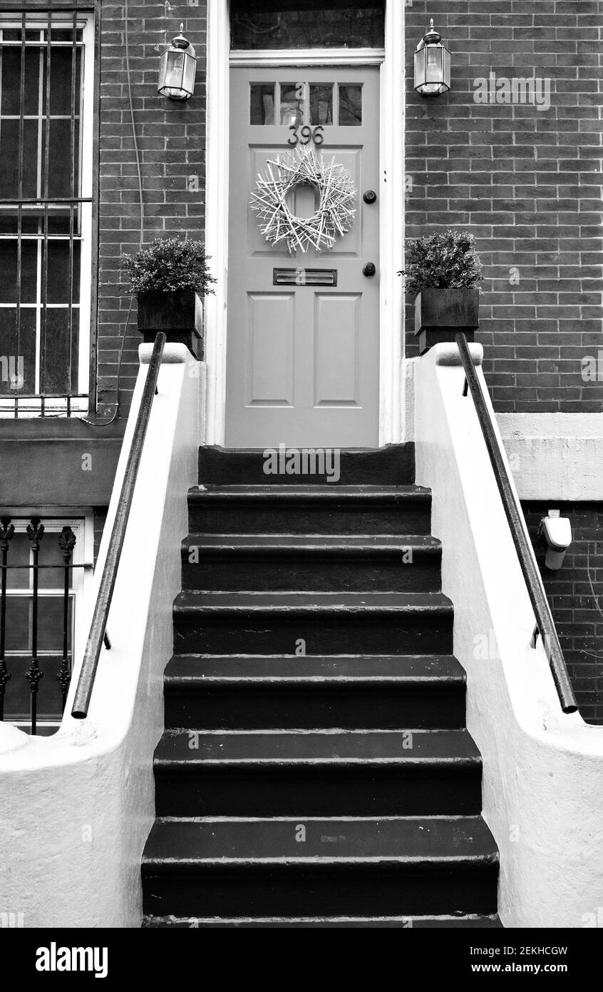 Porte d'entrée aux tons clairs sur des briques bruns à Brooklyn, New York, New York, USA. Des marches peintes mènent à la porte d'entrée de cette façade de bâtiment résidentiel. Banque D'Images