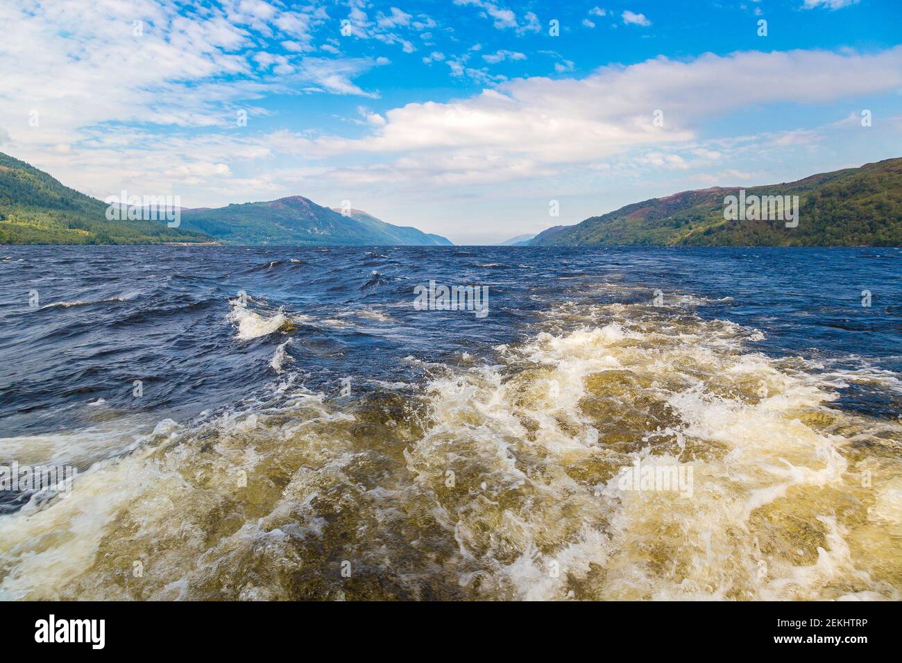 Sentier sur la surface de l'eau derrière le bateau à moteur sur le Loch Ness en Écosse, dans une belle journée d'été, Royaume-Uni Banque D'Images