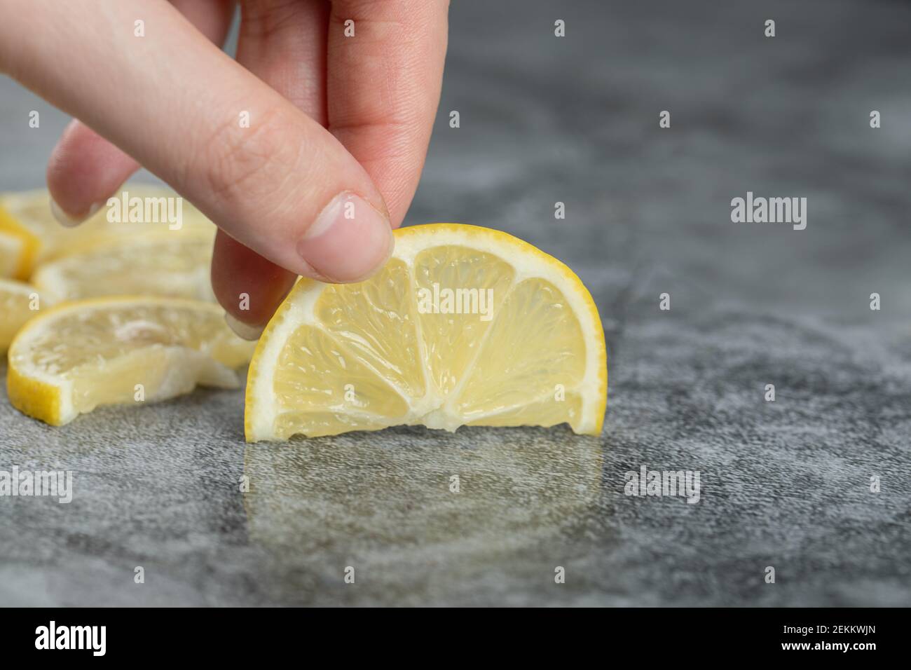 Tranches de citron aigre sur fond gris Banque D'Images