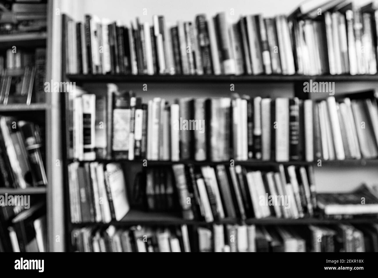 Les livres hors de focus sur une étagère dans une maison créent un design abstrait. Banque D'Images